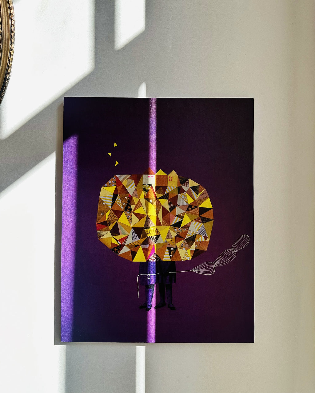 A framed Canva illustrated abstract artwork featuring geometric shapes and a figure, displayed on a wall.
