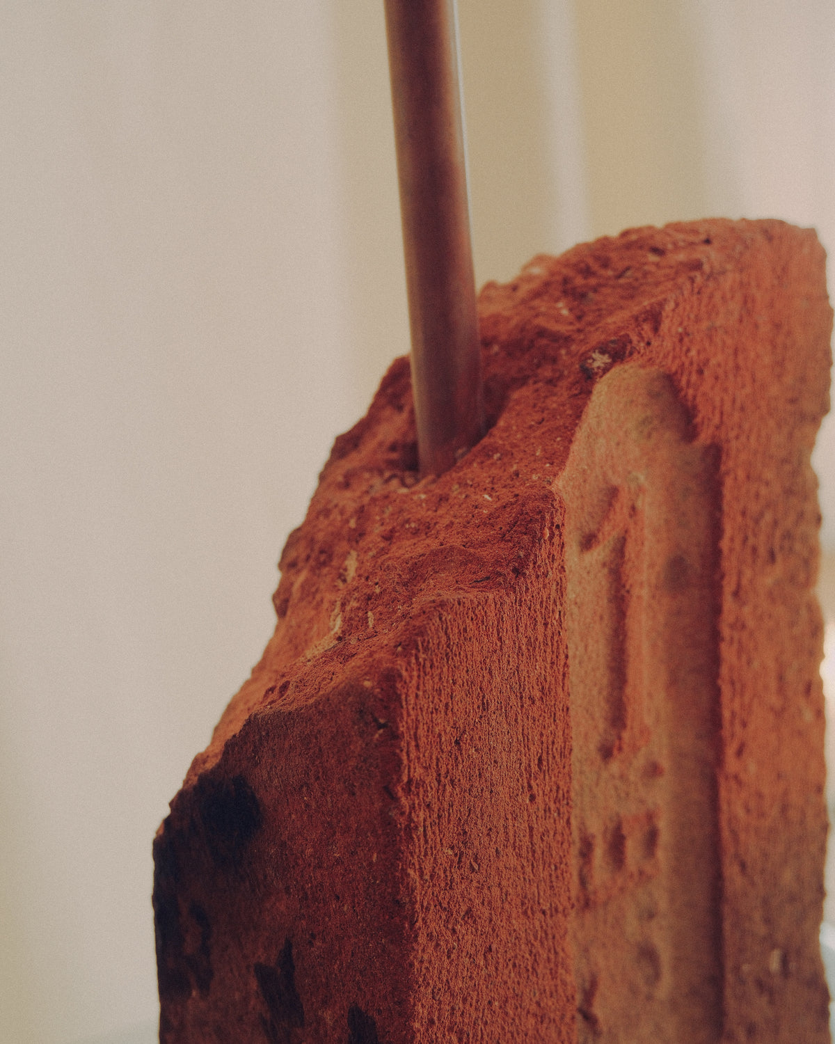 A close-up of a rustic terracotta brick lamp