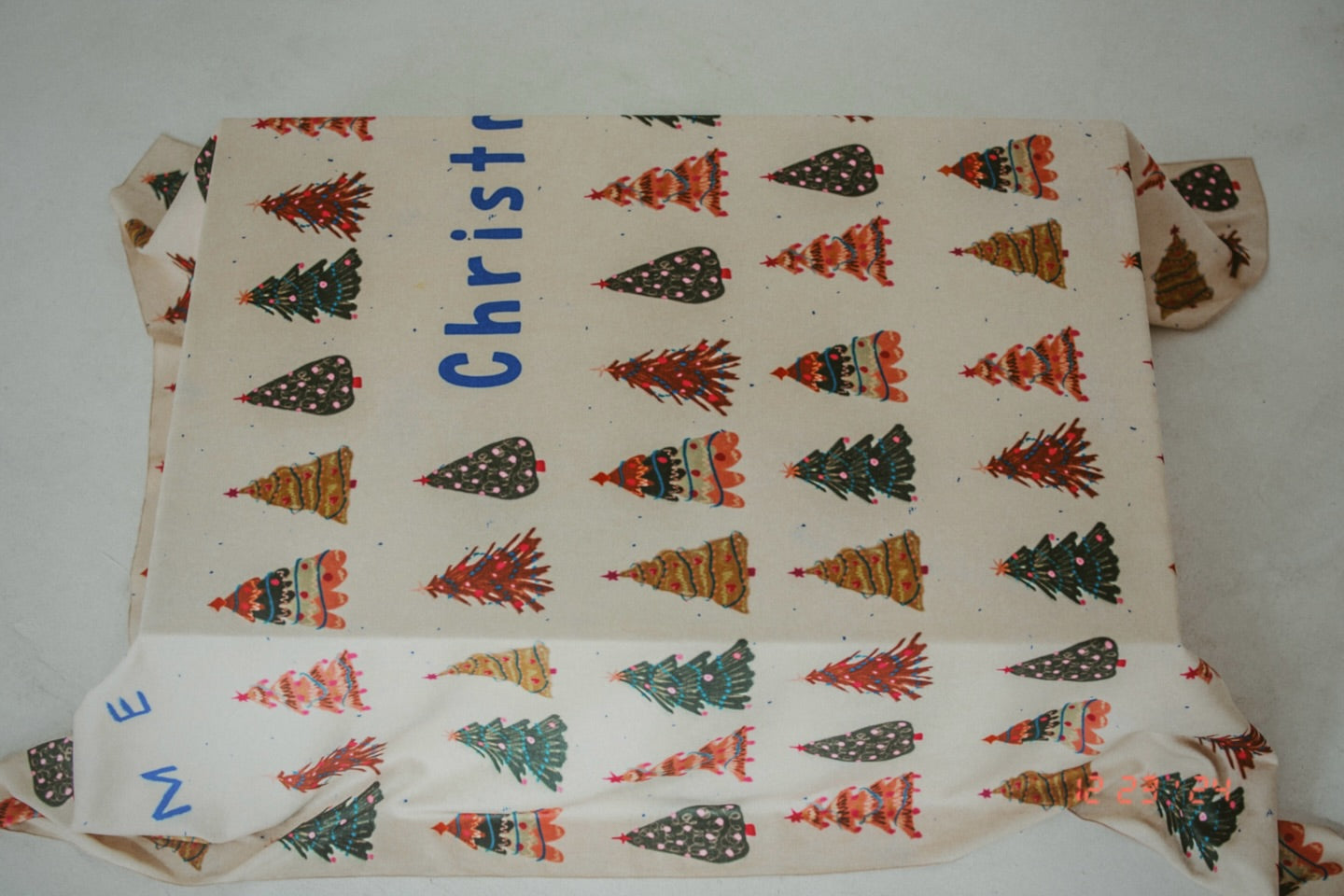 Fabric with Christmas tree pattern and 'Christmas' text on a white background