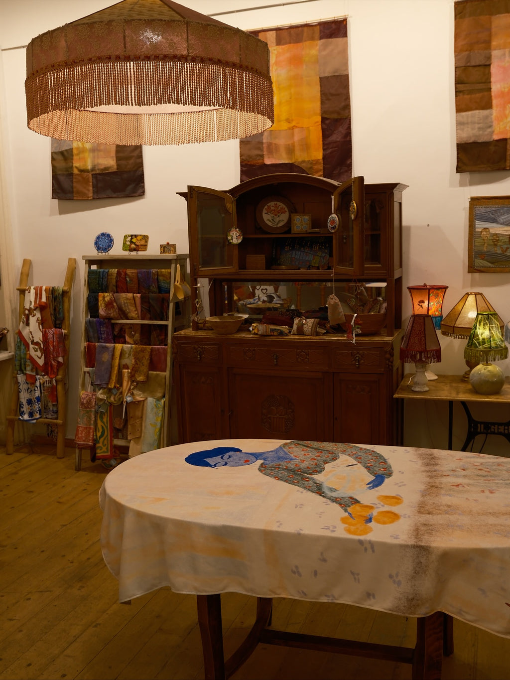 Room interior with wooden furniture, tablecloth with design, and wall art.