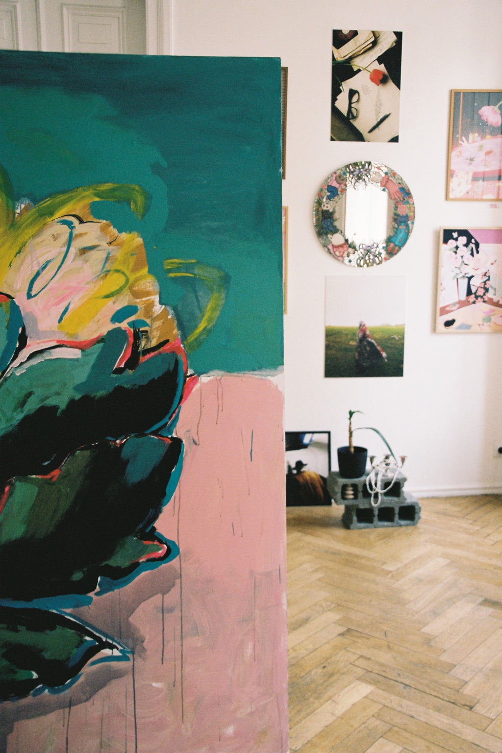 Artistic wall display with a large abstract painting and smaller framed artworks on a white wall.