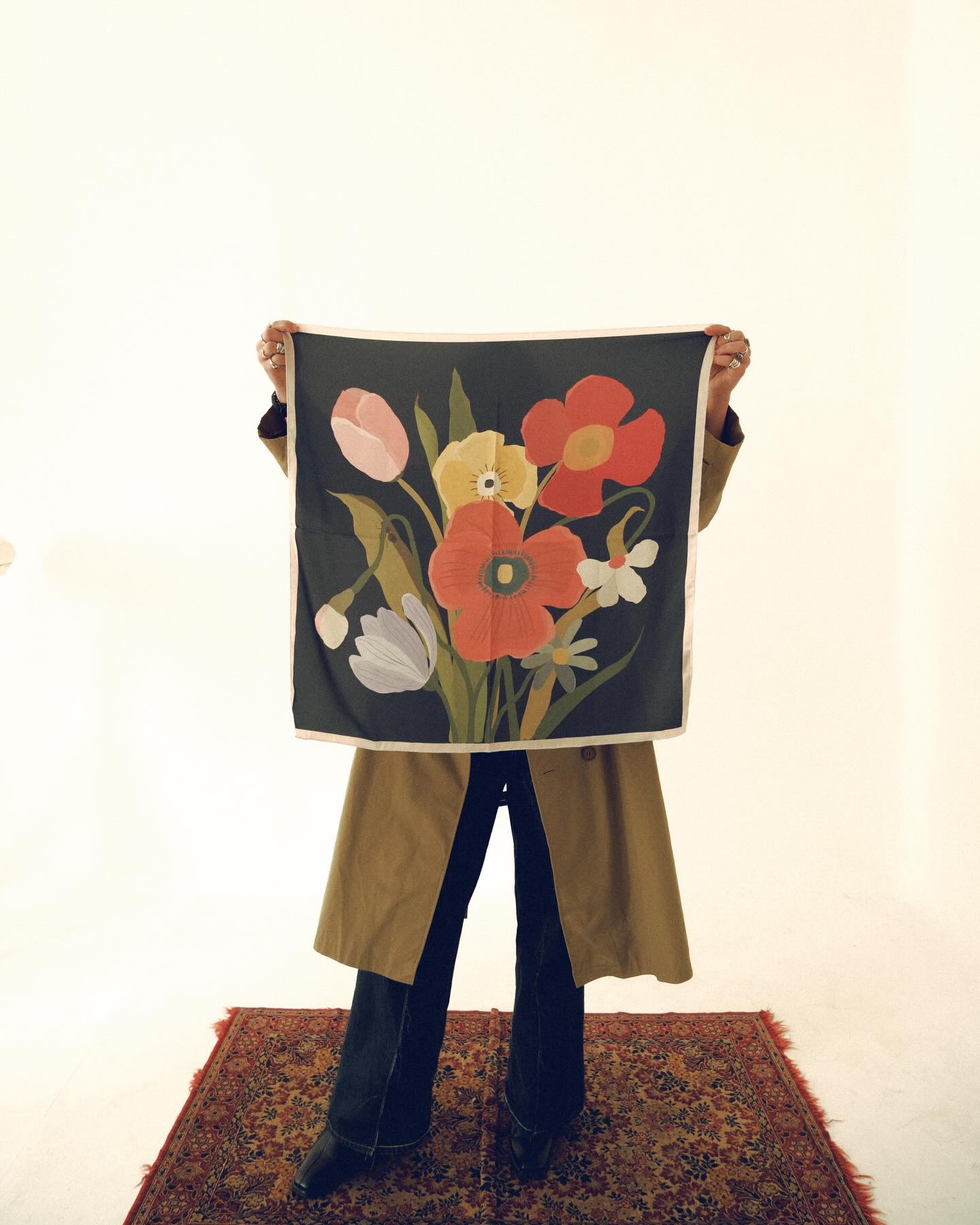 Person holding a floral-patterned fabric against a plain background