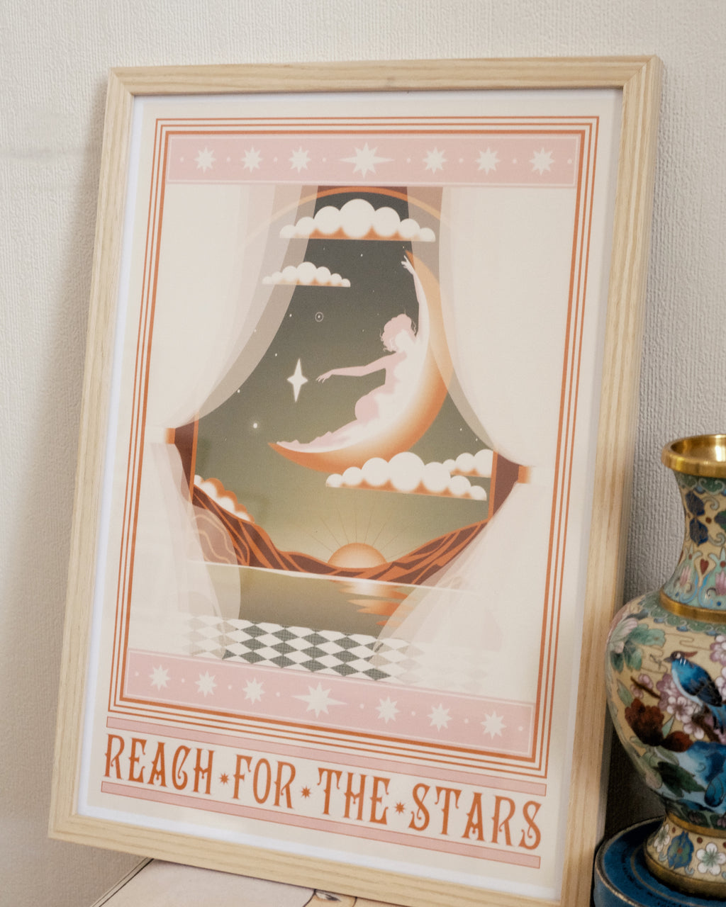 “Reach for the Stars” poster styled in a cozy interior with art prints and vintage decor, captured in natural daylight