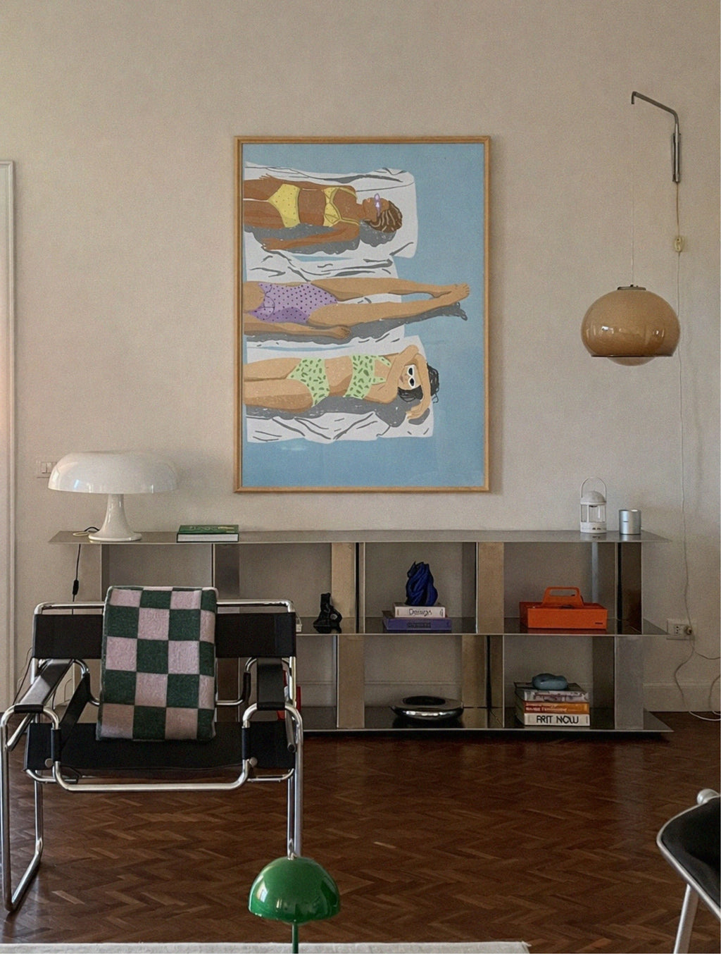 Modern interior with a chair, shelf, and artwork on a wall.