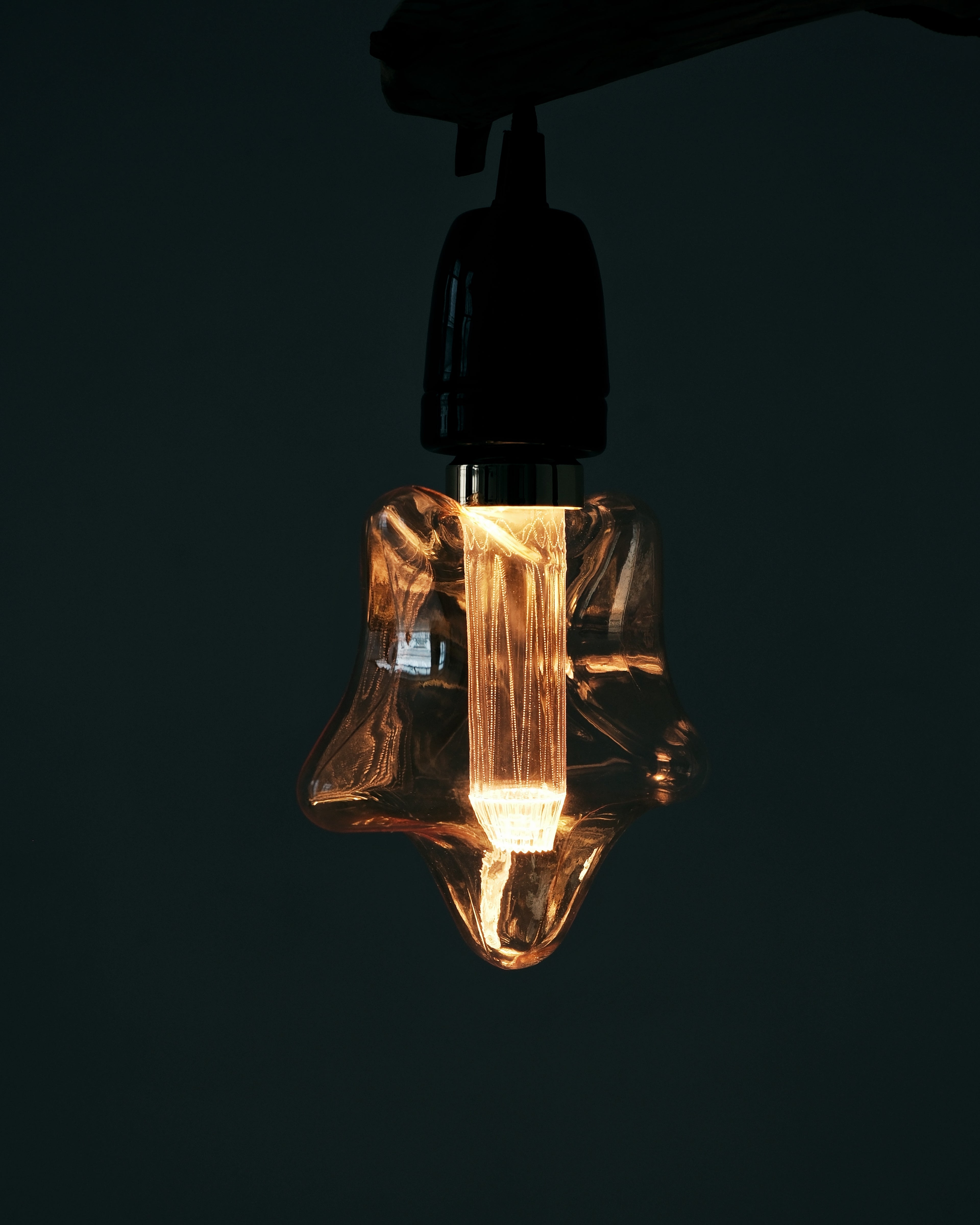 Edison bulb with a star-shaped design on a black background