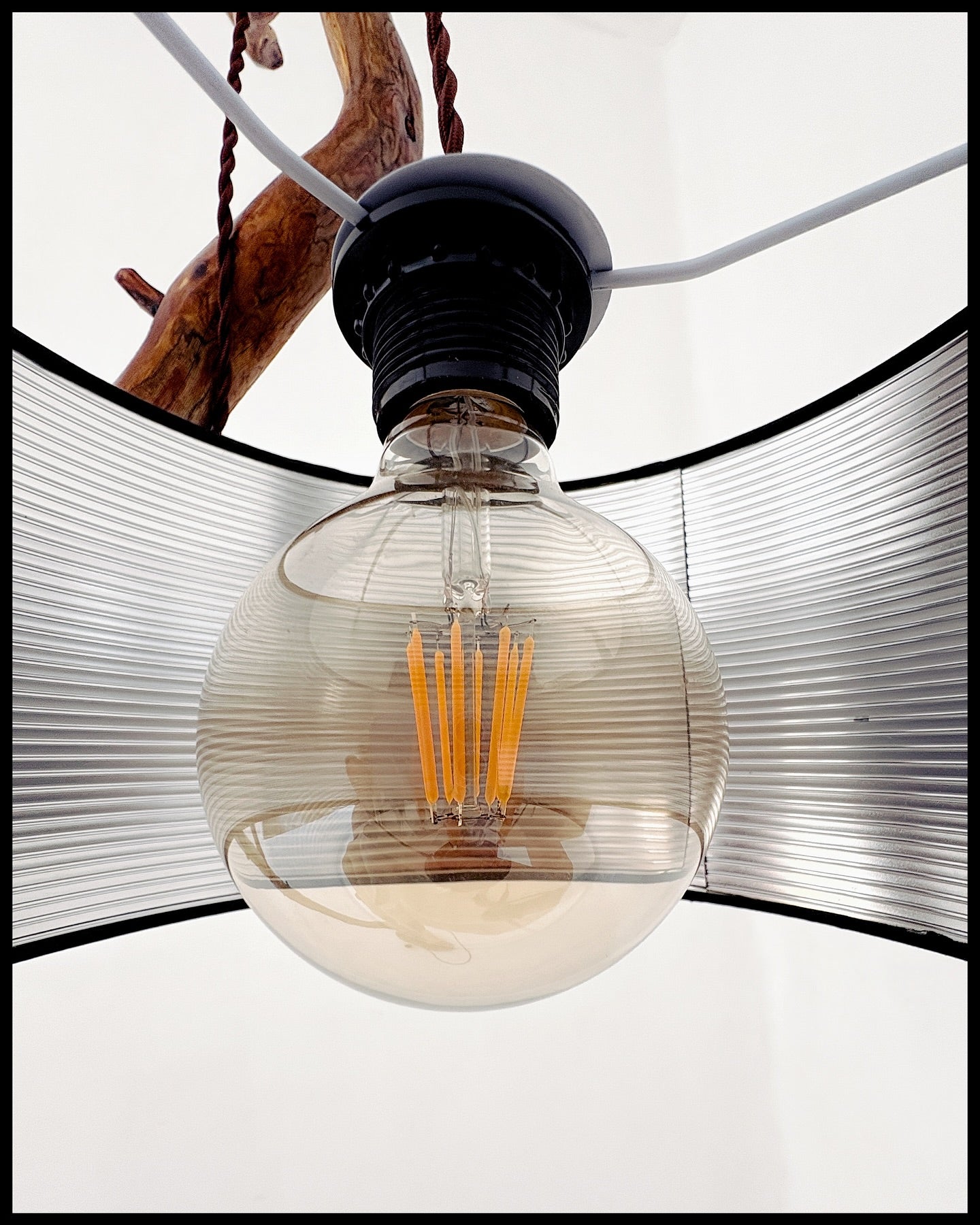 Vintage-style light bulb with decorative shade on a white background