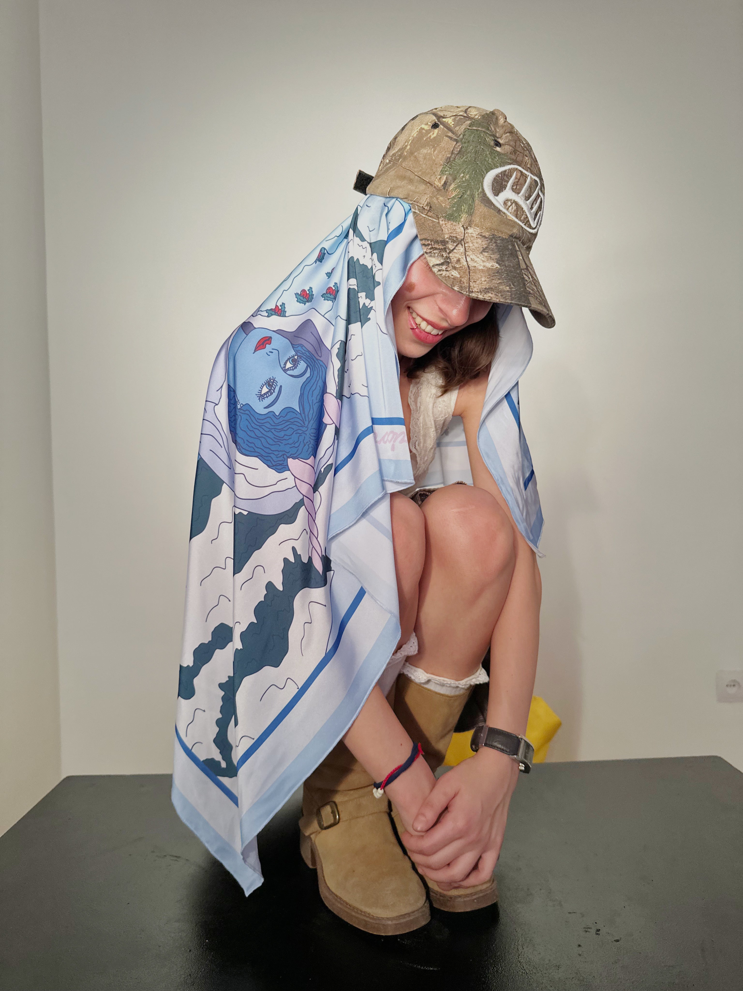 Capricorn zodiac silk scarf in soft blue and beige draped over model’s back, illustrated by Anano Kevanishvil