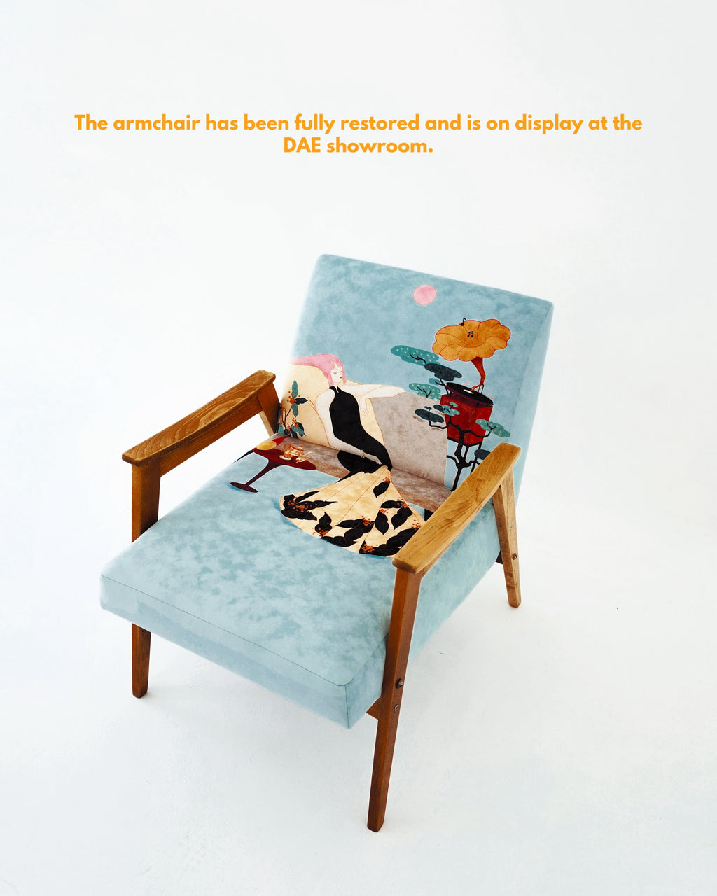 Decorative armchair with a light blue cushion featuring artistic designs on a white background.