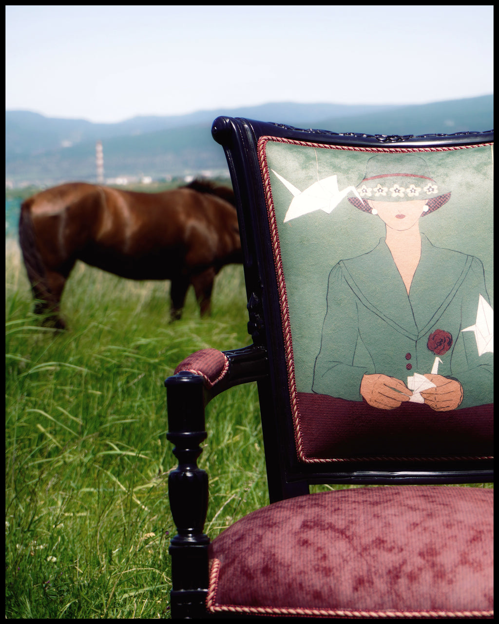 Chair with a decorative textile featuring a woman's portrait, horse in the background