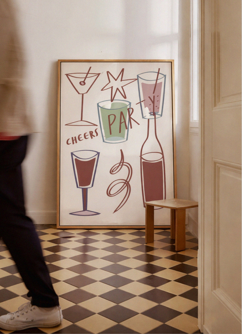 Framed artwork with cocktail illustrations on a checkered floor