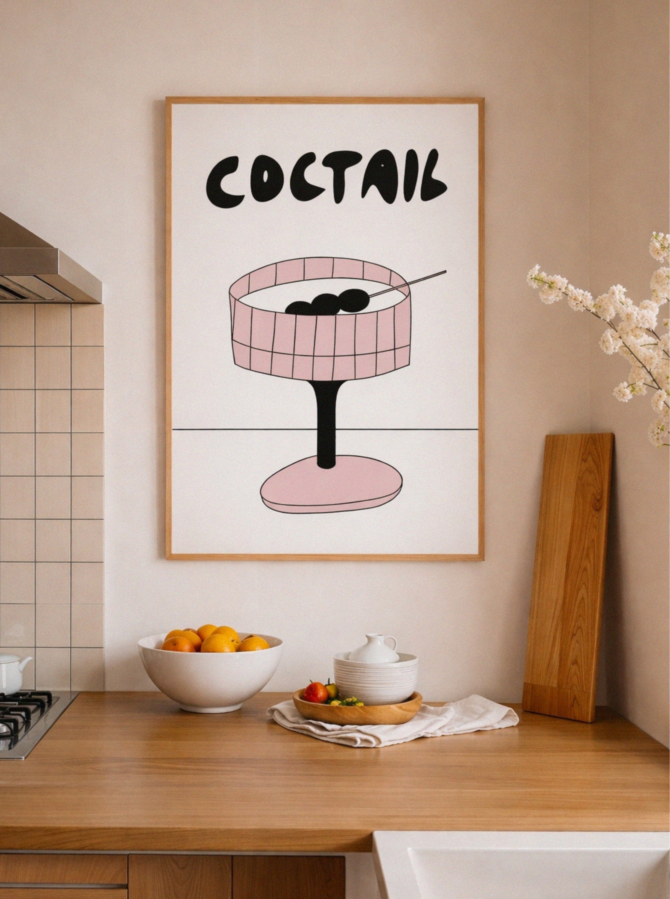 Framed artwork with 'COCTAIL' text and a pink cocktail glass on a kitchen wall.