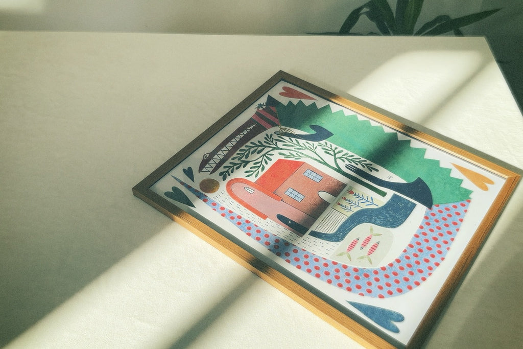 A poster featuring an illustration with abstract and geometric elements, predominantly in blue and green shades, depicting a scene with a house and a crocodile. Poster “Crocodile House” by Feli Beringer – playful wall art illustration printed on paper, available framed or unframed by DAE • დაე.