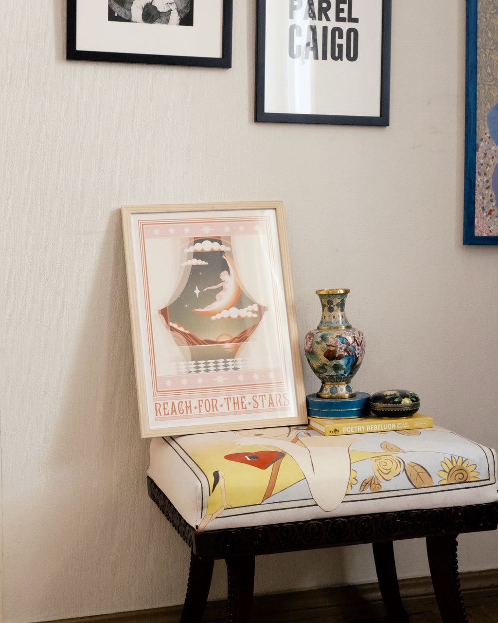 Framed “Reach for the Stars” poster by Bianca Roberts x DAE featuring a surreal figure sitting on the moon in soft pastel hues