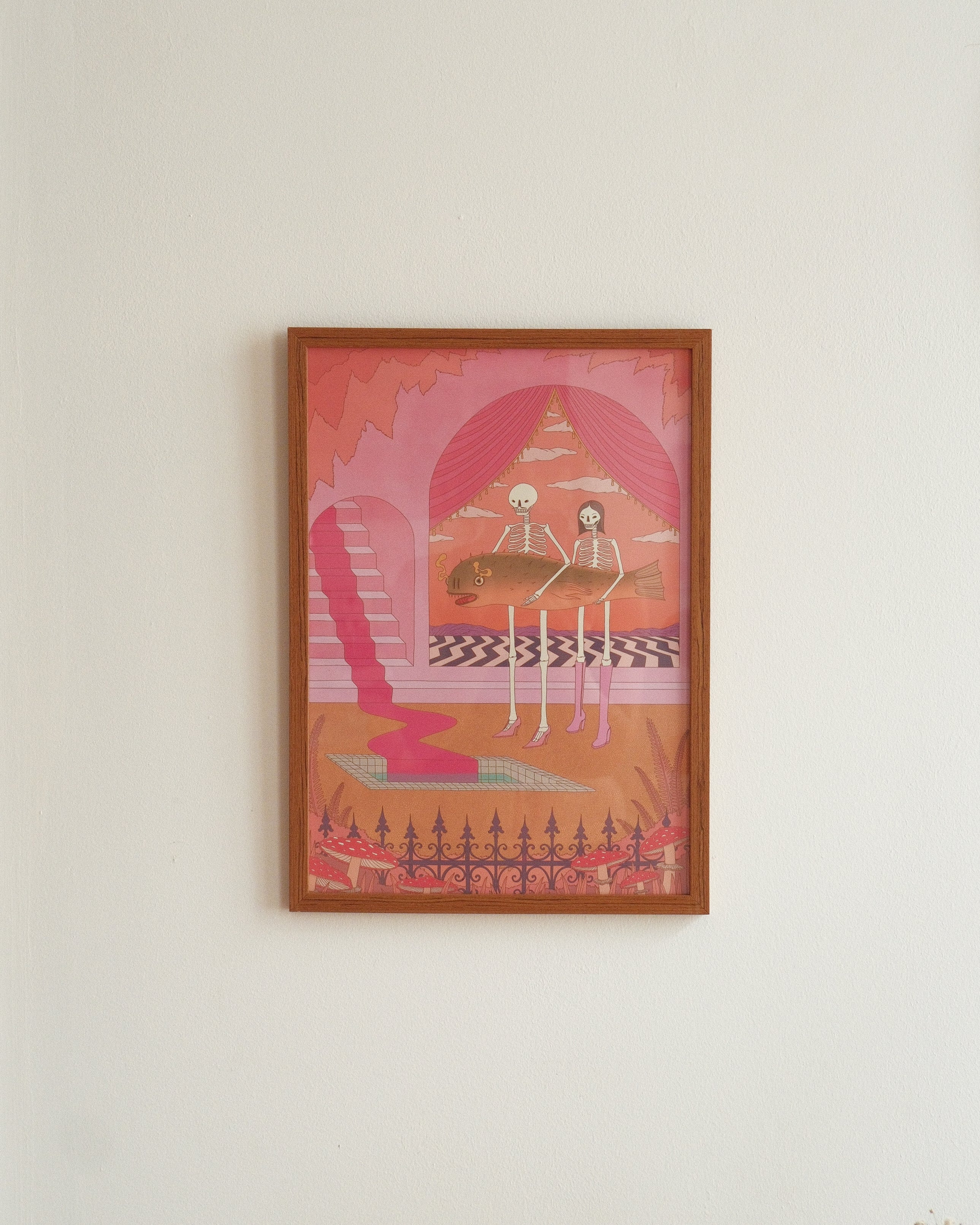 Framed artwork with a pink and orange color scheme on a white wall