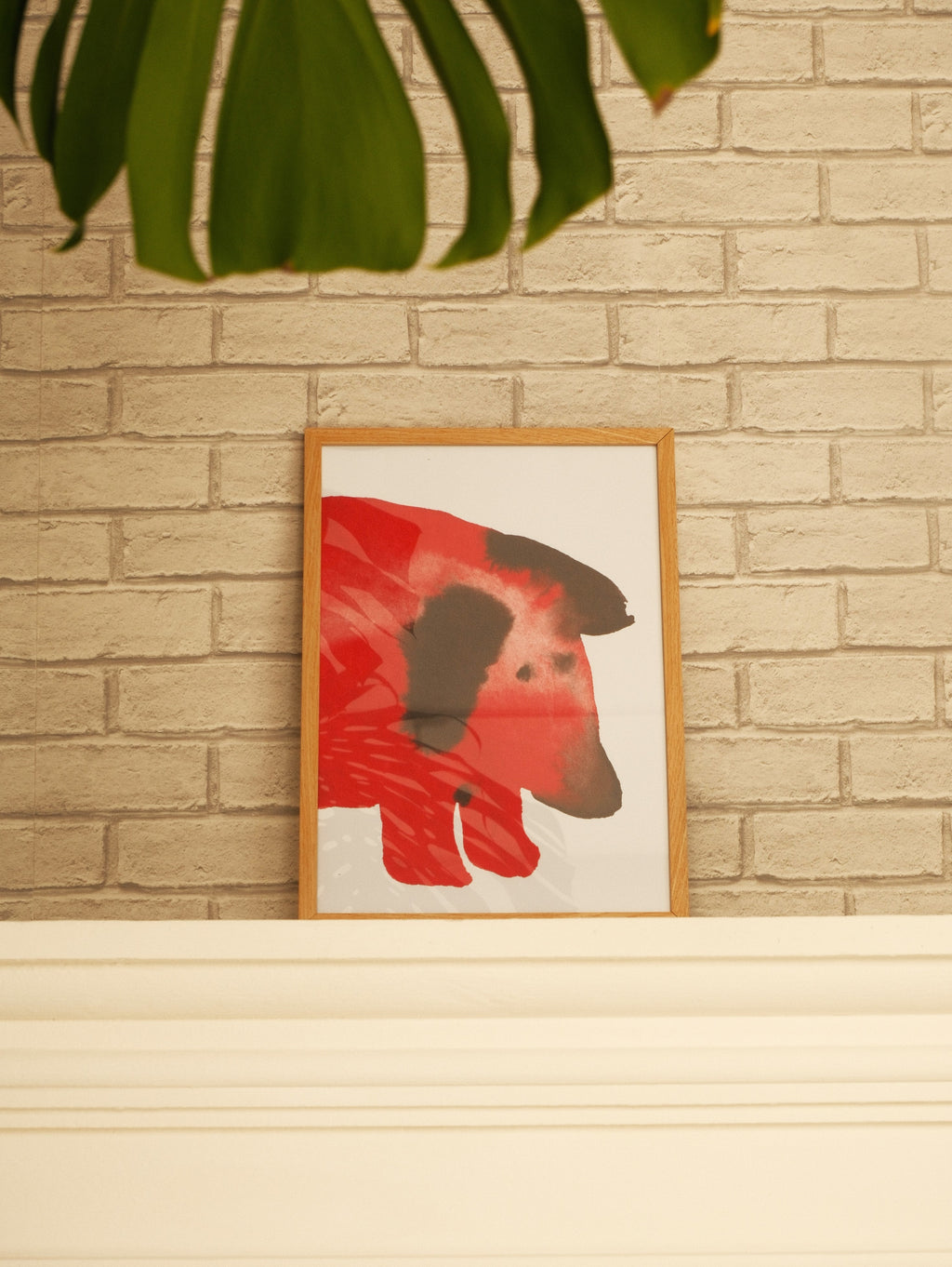 Framed artwork of a red dog on a brick wall