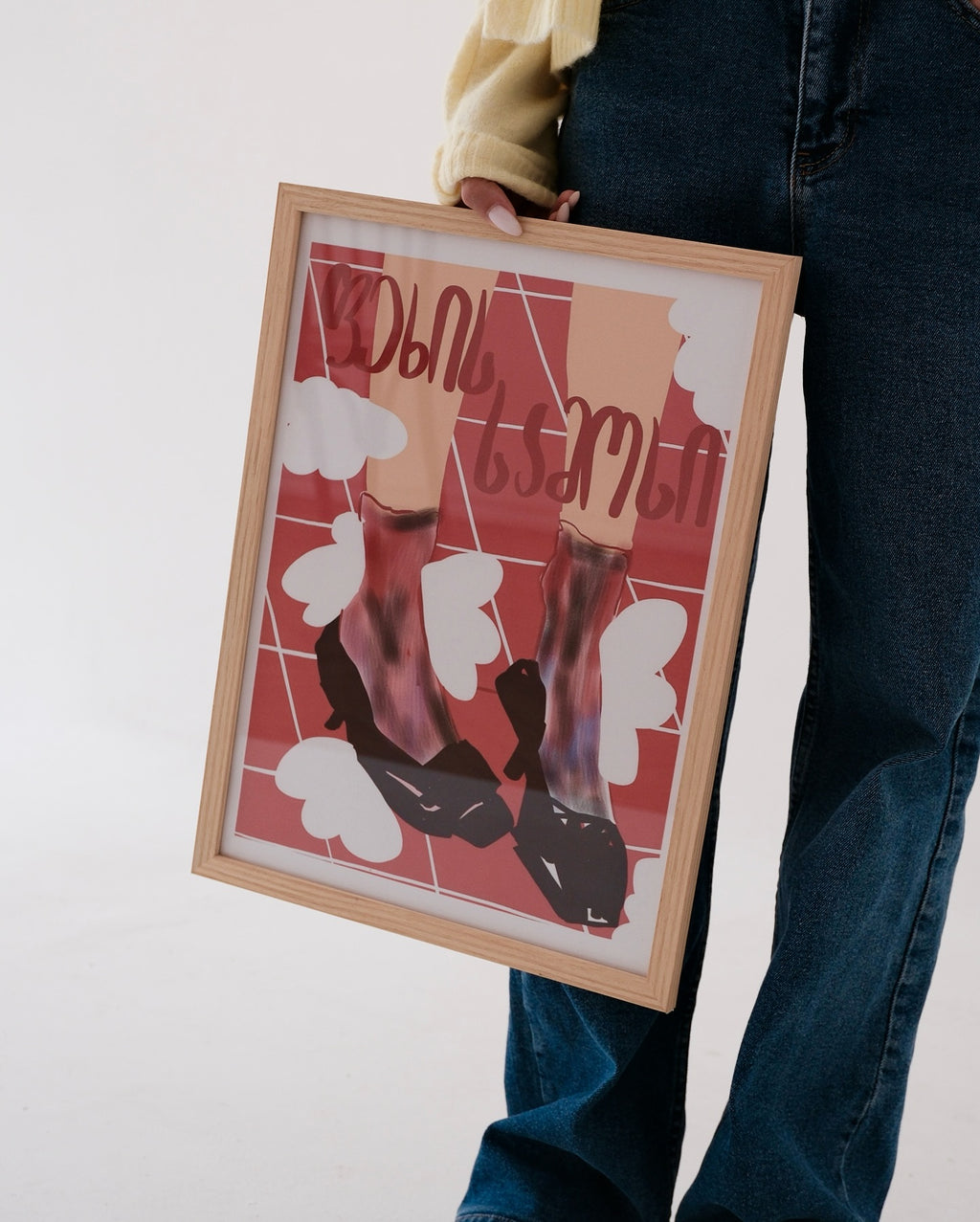 Person holding a framed artwork with abstract design and text in georgian language