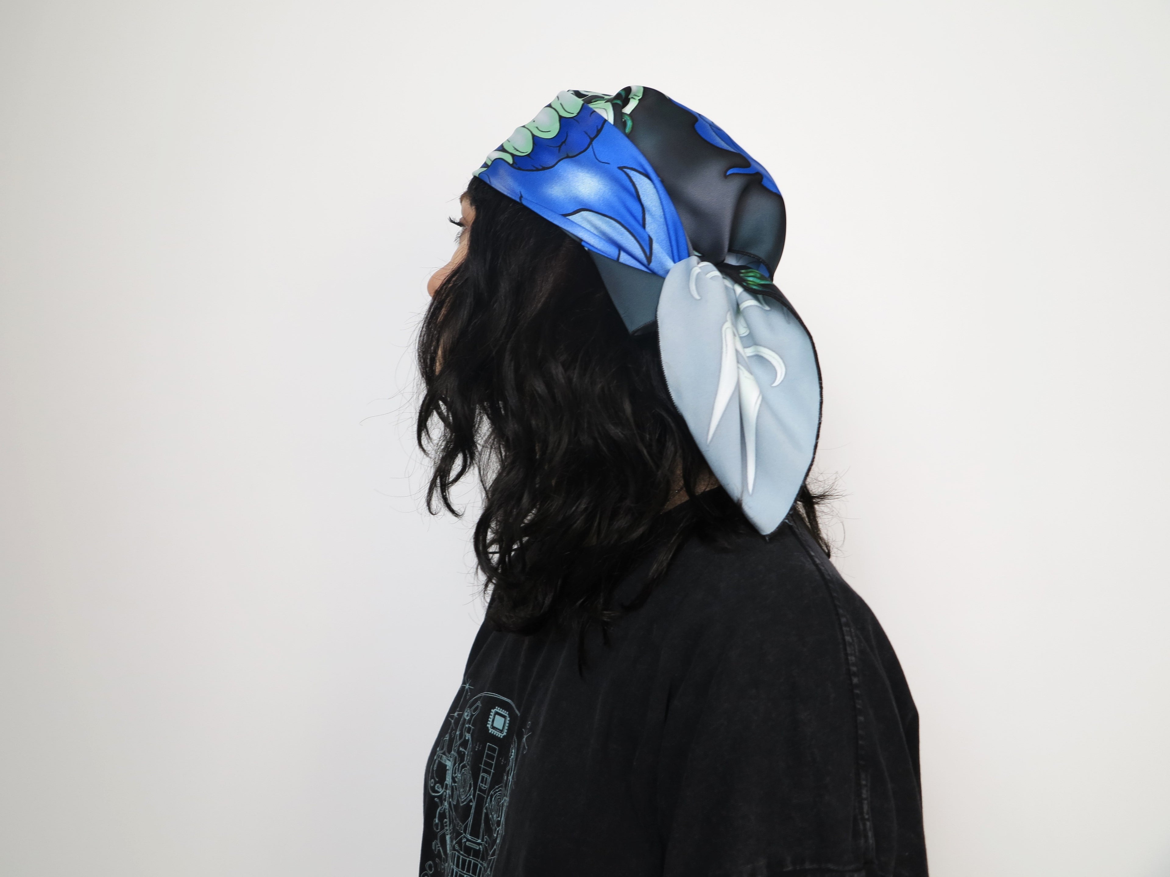 Model wearing PetalPixie Electric Bloom scarf styled as headpiece with vibrant blue floral artwork