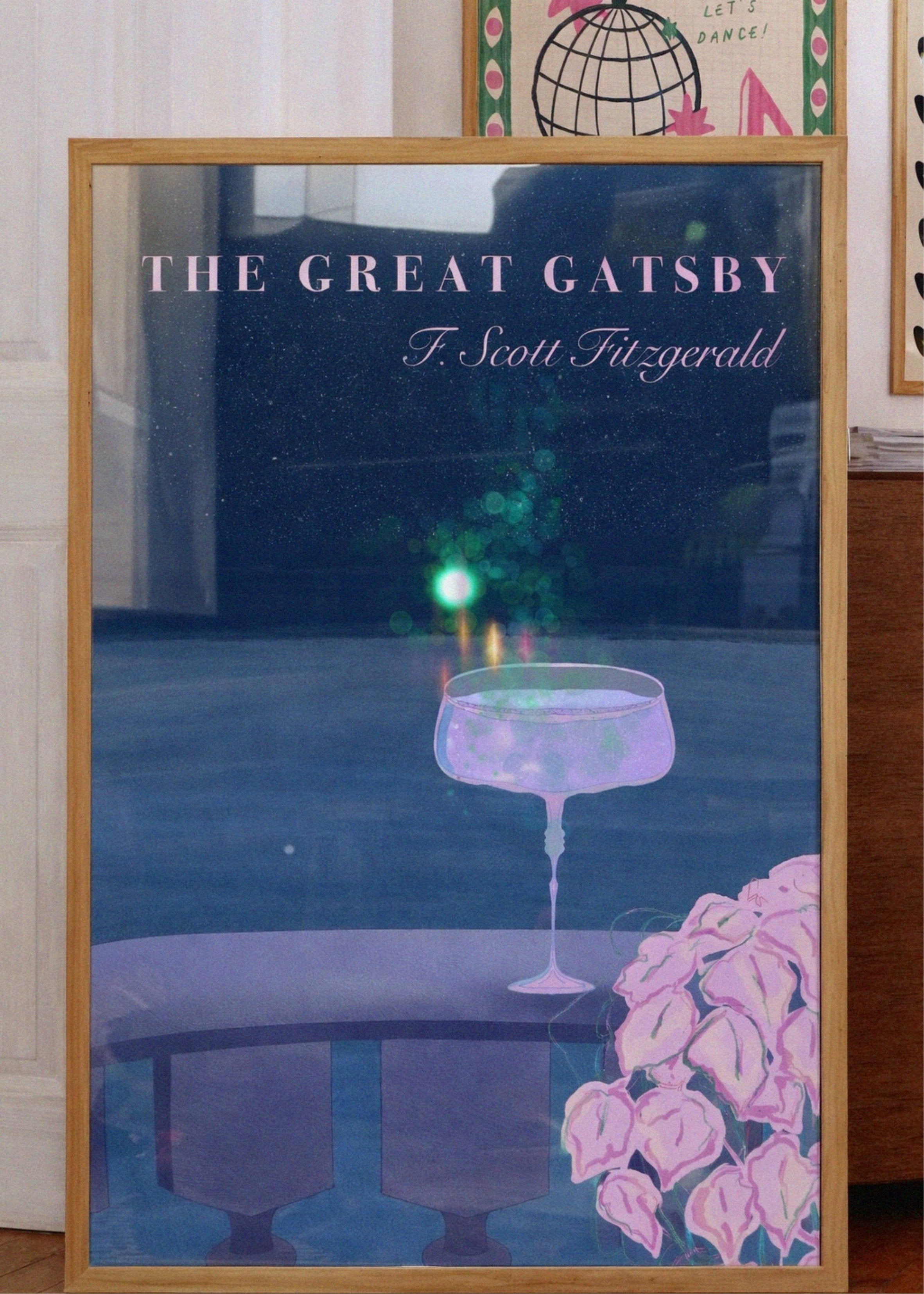 Framed poster of 'The Great Gatsby' with a glass and flowers on a table.
