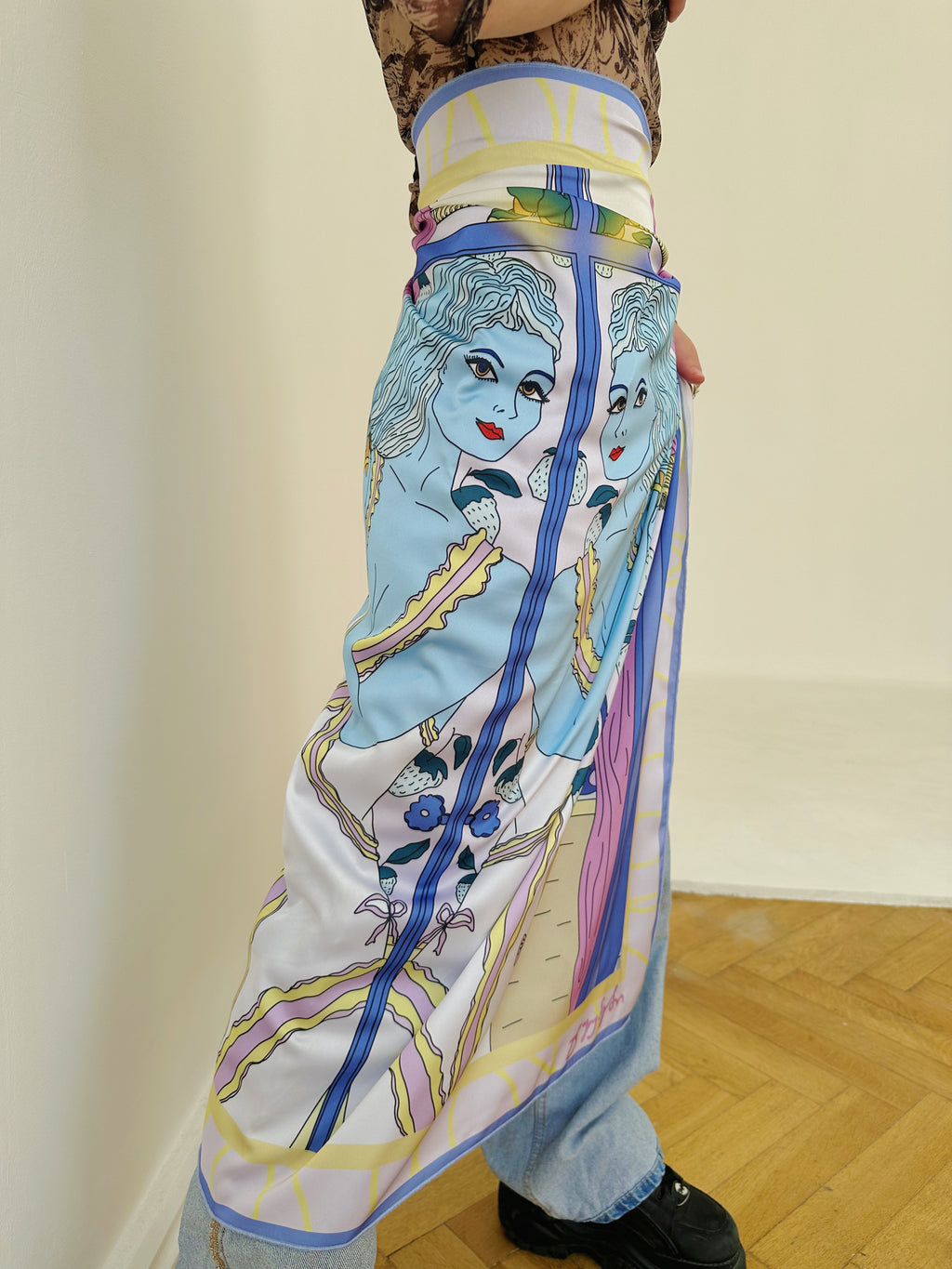 Model holding Gemini zodiac illustrated scarf with colorful Georgian-inspired details