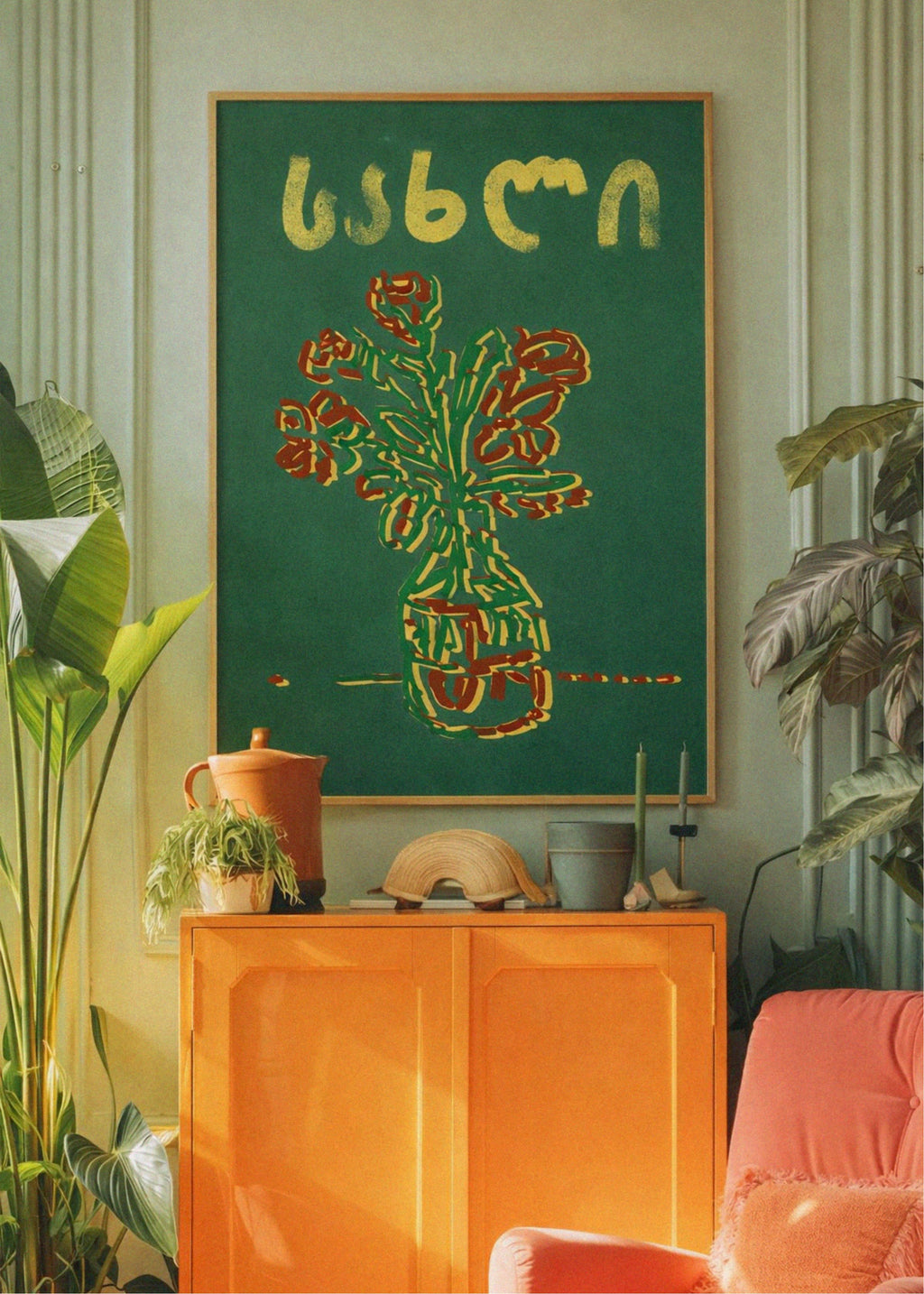 Room interior with a green abstract painting on an orange cabinet, surrounded by plants.