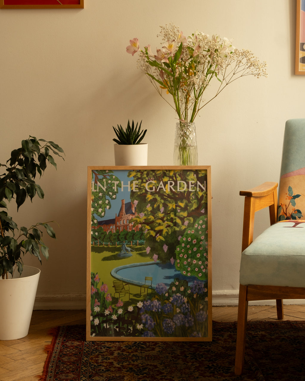“In the Garden” poster by Anano Kevanishvili featuring a colorful spring garden inspired by Paris’ Tuileries Garden, standing in interior, next to armchair and plants