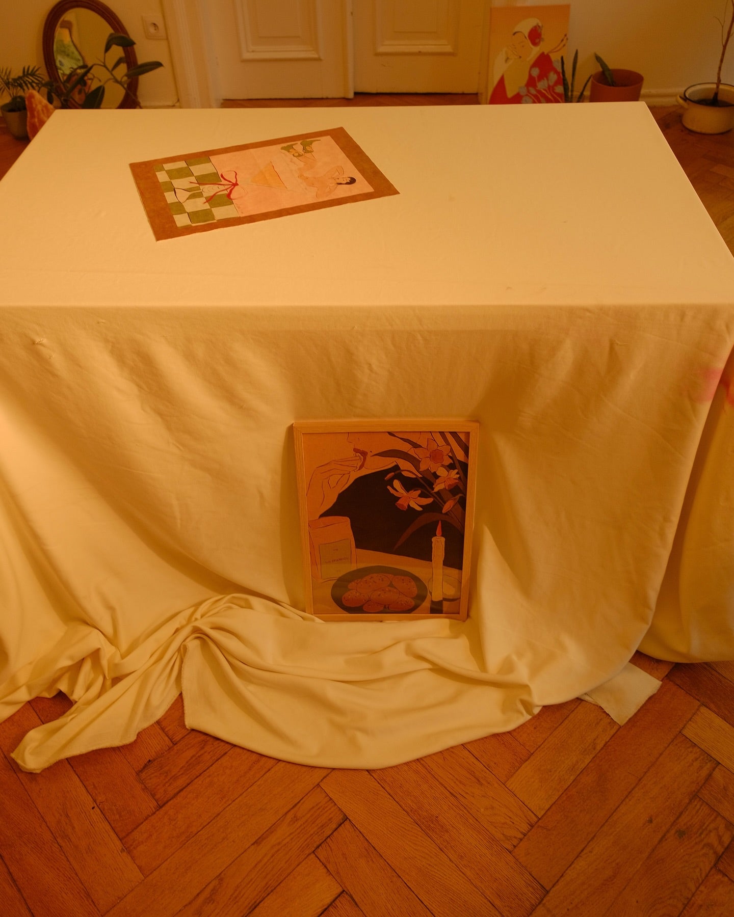 poster on the floor another on on the table, interior photo with different posters by the same artist