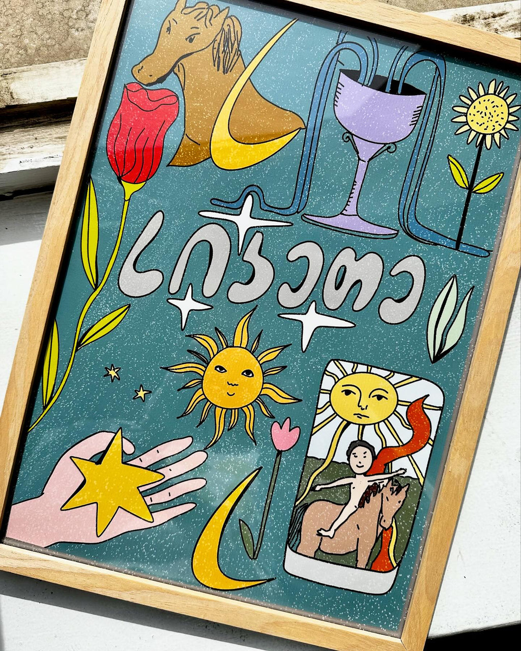 A colorful poster featuring various illustrations such as a horse, a wine glass, a sun, a moon, and other abstract designs with the text 'KINDNESS' prominently displayed.