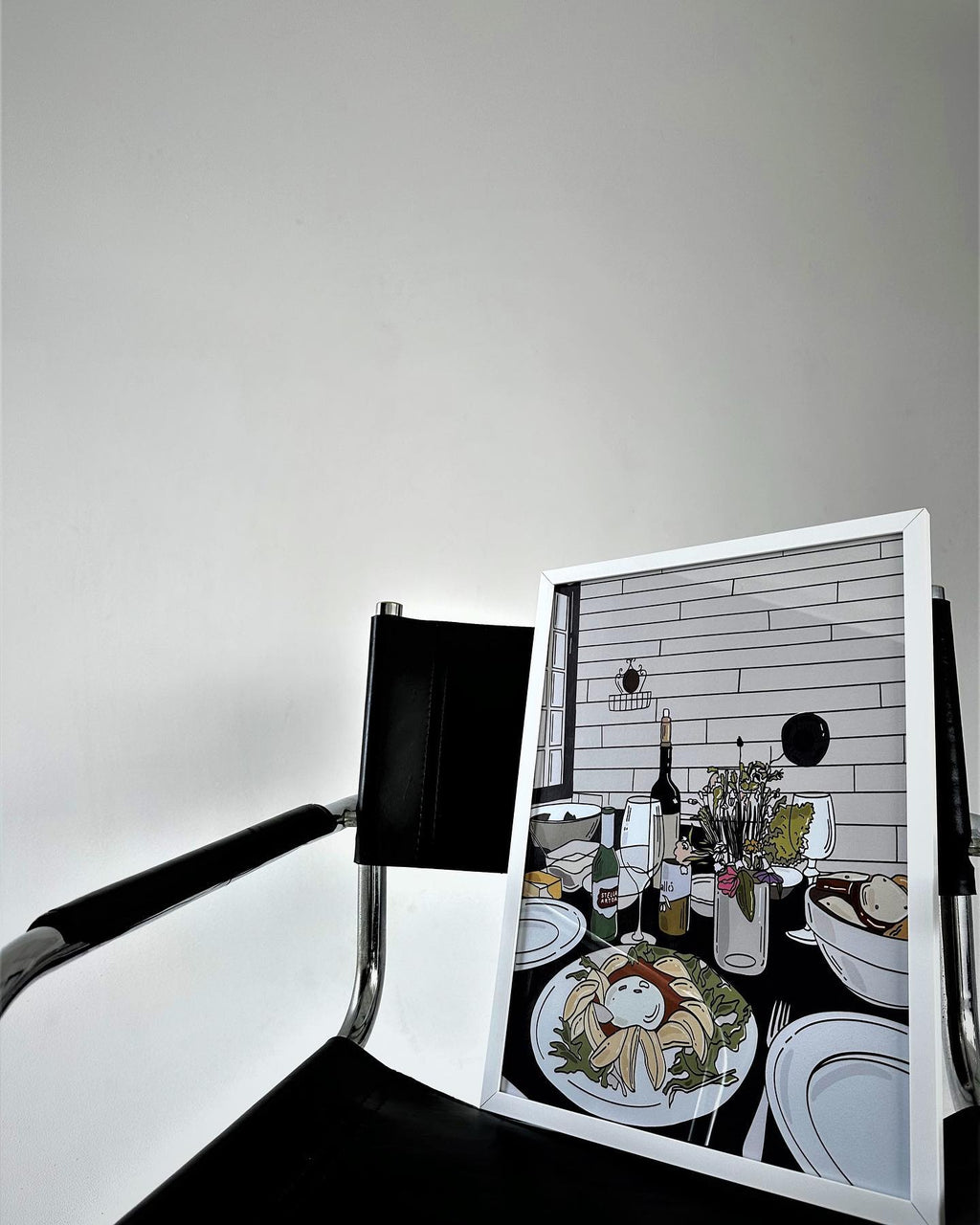 Framed artwork of a dining scene with a chair in front of it. Table art poster by Oliko Tkebuchava - minimalist wall decor.