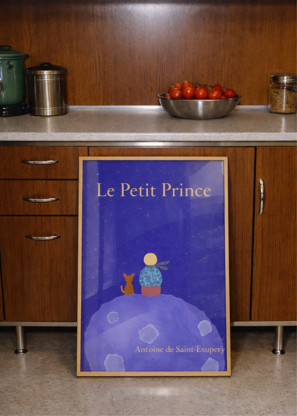 Framed 'Le Petit Prince' book cover in a kitchen setting
