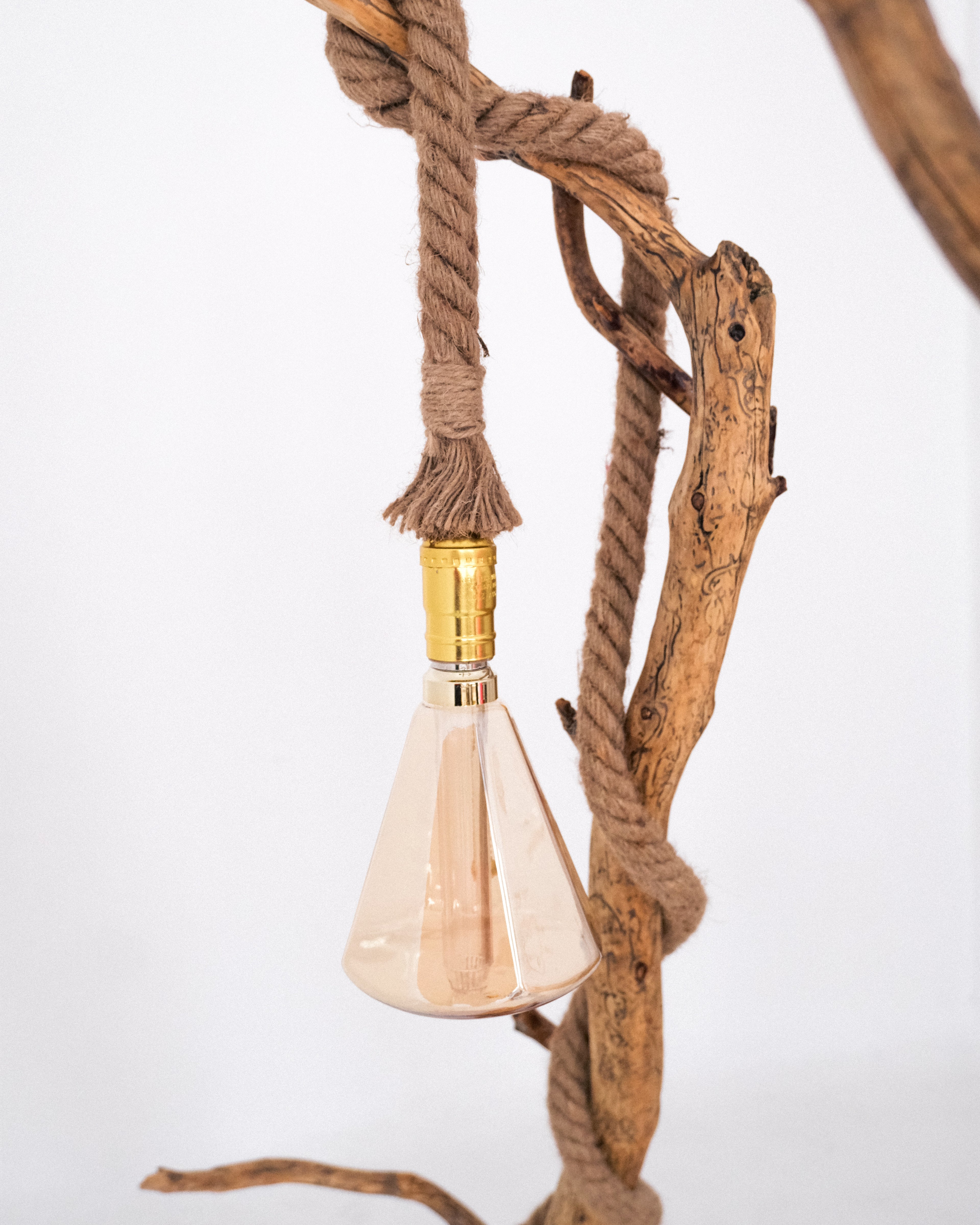 Decorative light fixture with a cone-shaped bulb and wooden elements on a white background