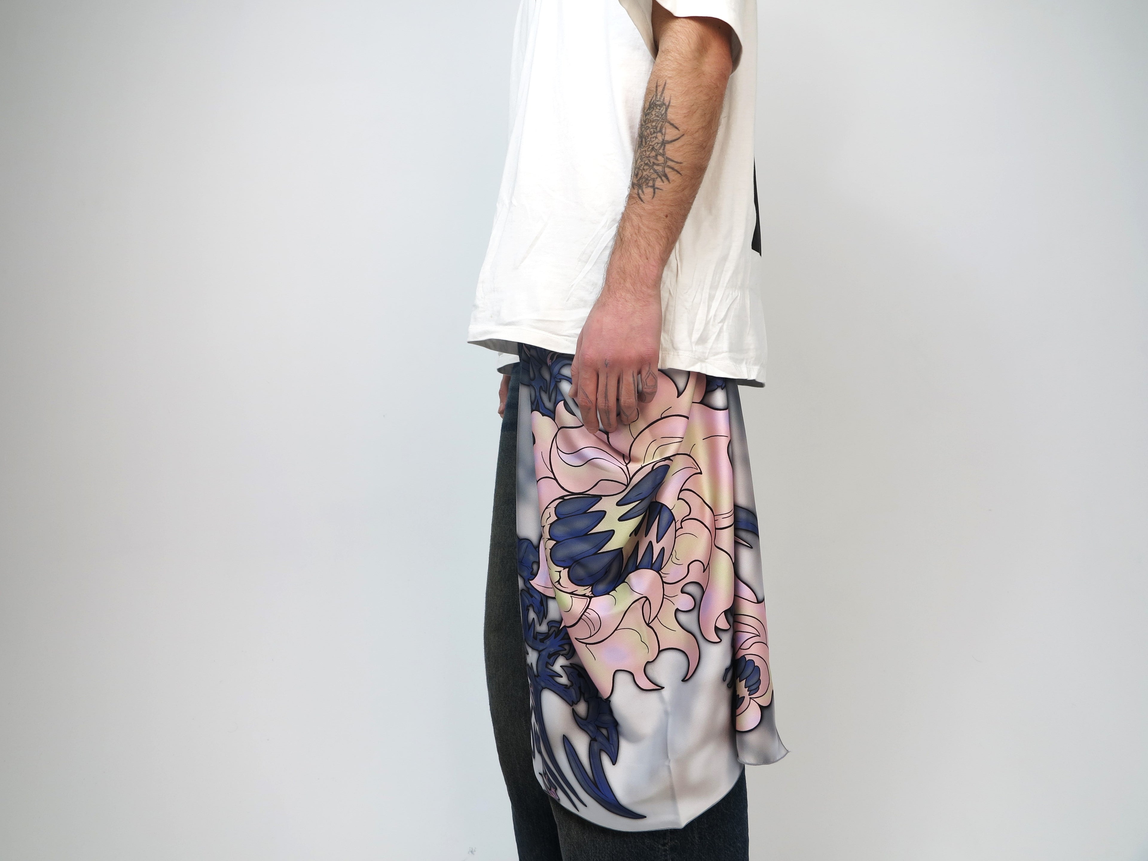 A person wearing a scarf with a floral and abstract pattern collaboration with an artist. PetalPixie Midnight Rose limited edition scarf in deep navy and blush floral tones