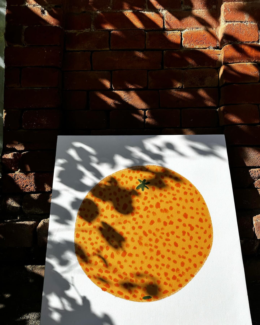 orange poster with white background, in the street, brick wall, shadows by the sun