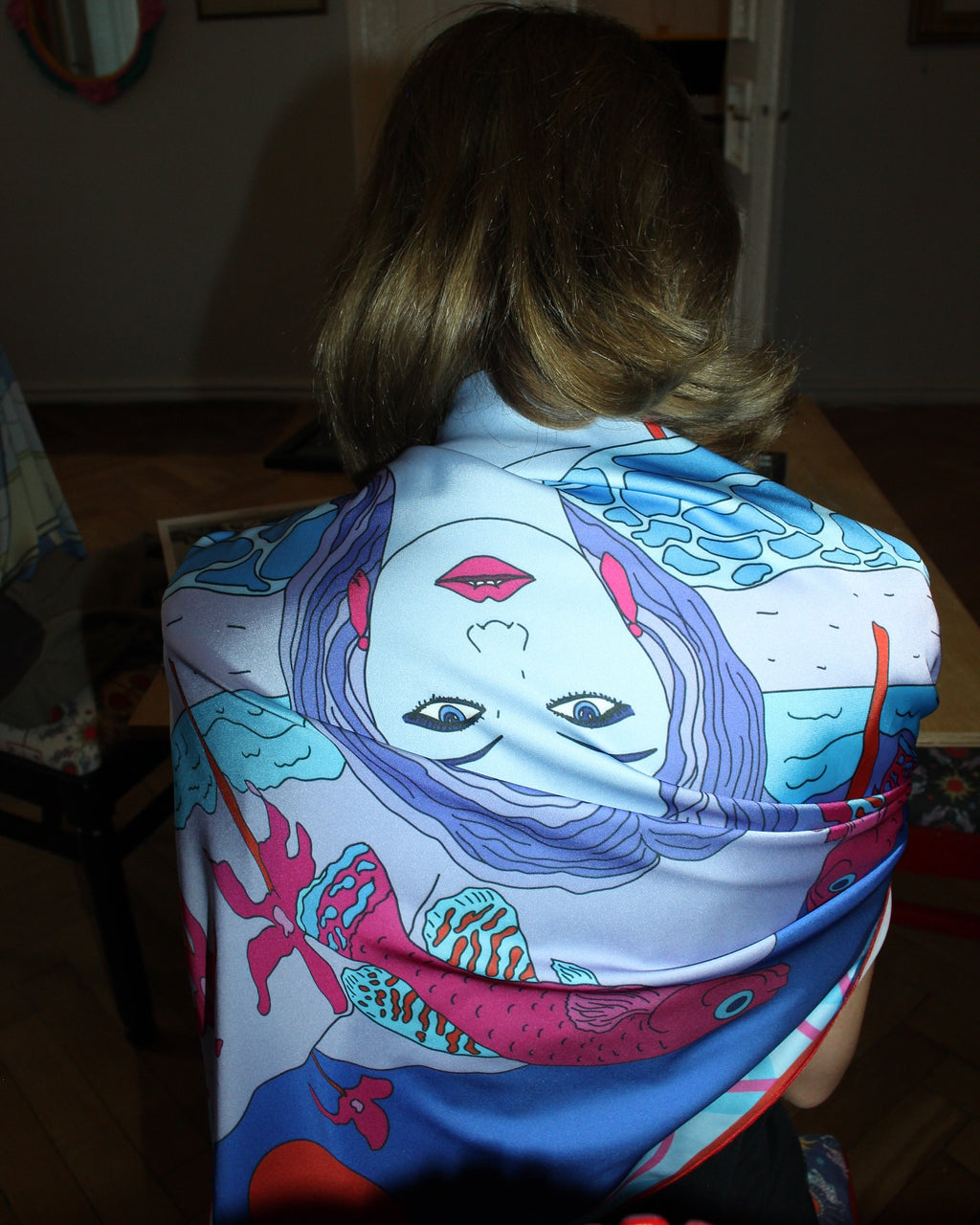 Pisces zodiac art silk scarf in pastel blue and pink worn by model from behind, illustrated by Anano Kevanishvili