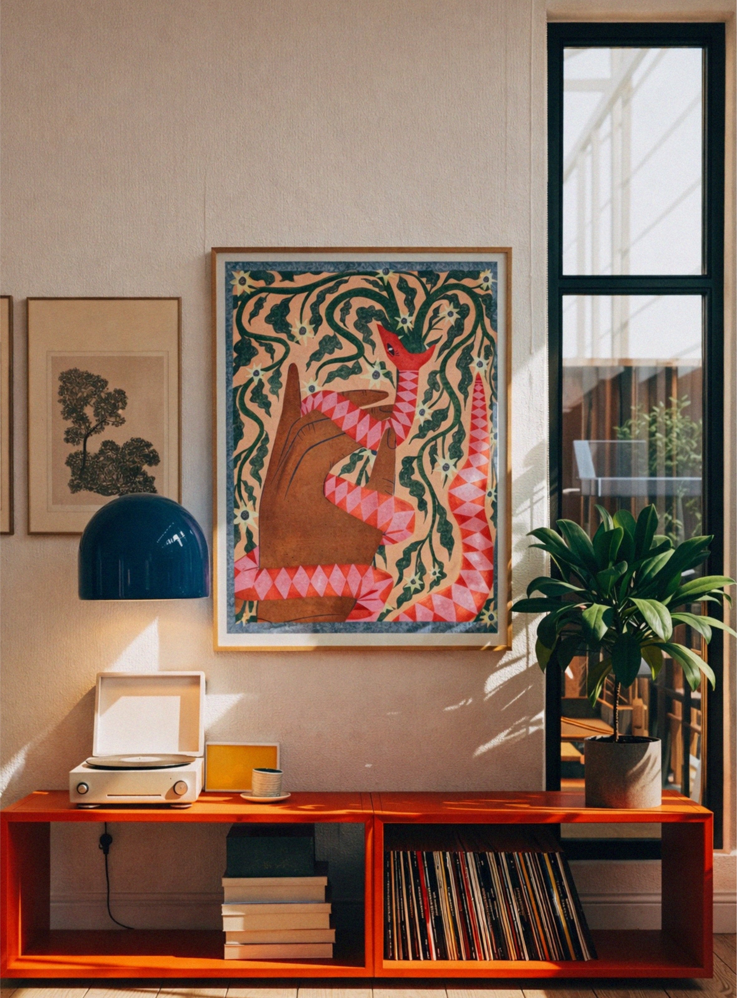Living room with orange shelf, colorful snake artwork, and plant