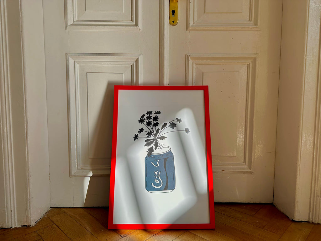 A poster with a minimalistic illustration of a bottle, placed against a door in an angled position.