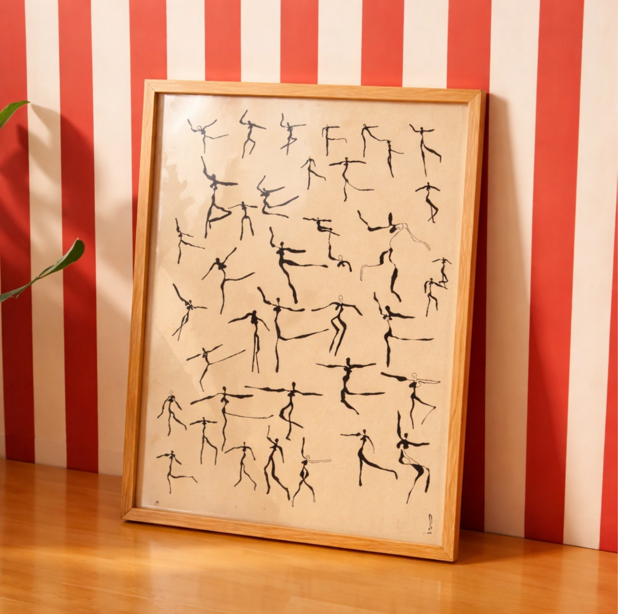 Framed artwork with stick figure dance poses against a red and white striped wall.