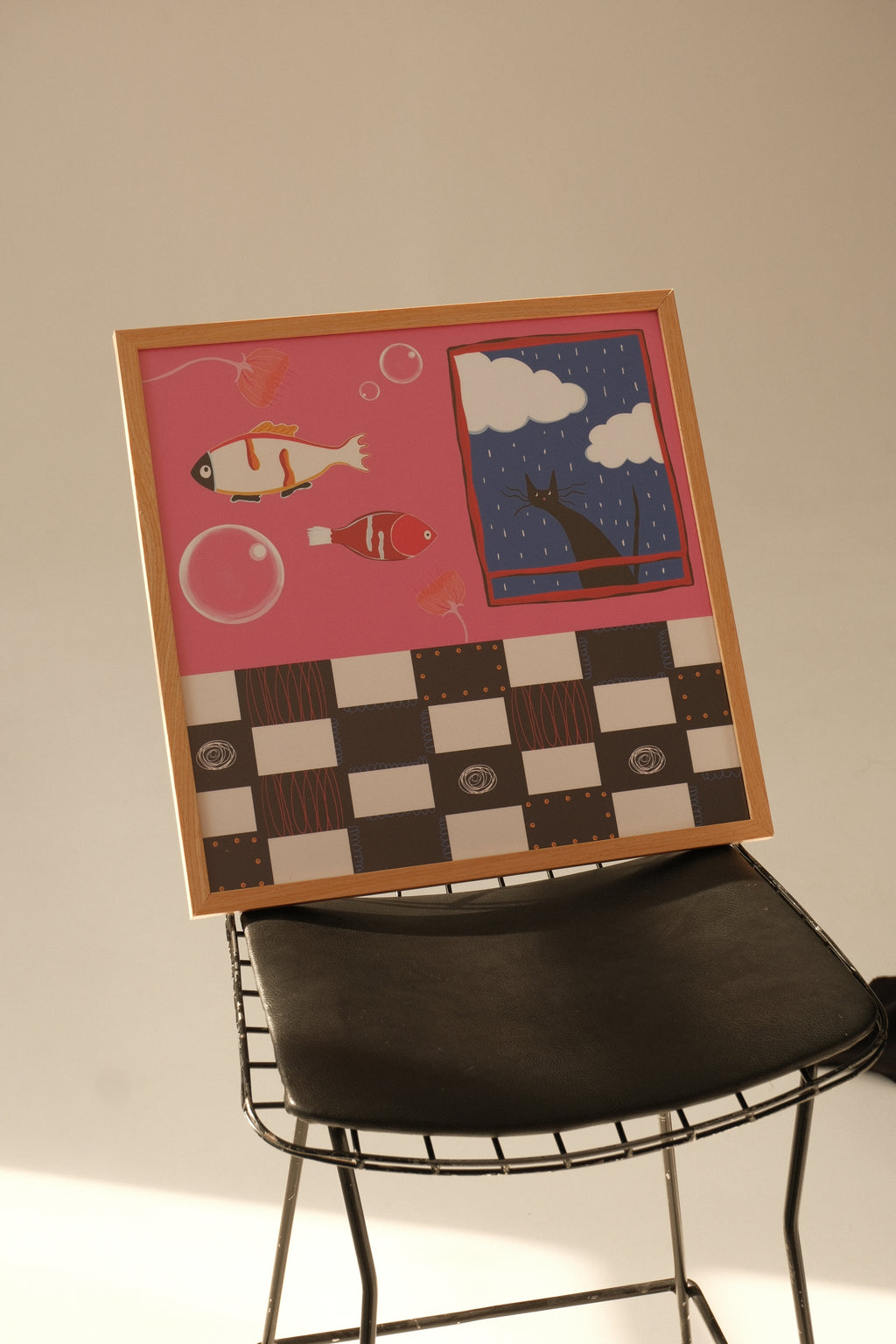 Decorative wall art with a pink background and checkered pattern on a white wall.