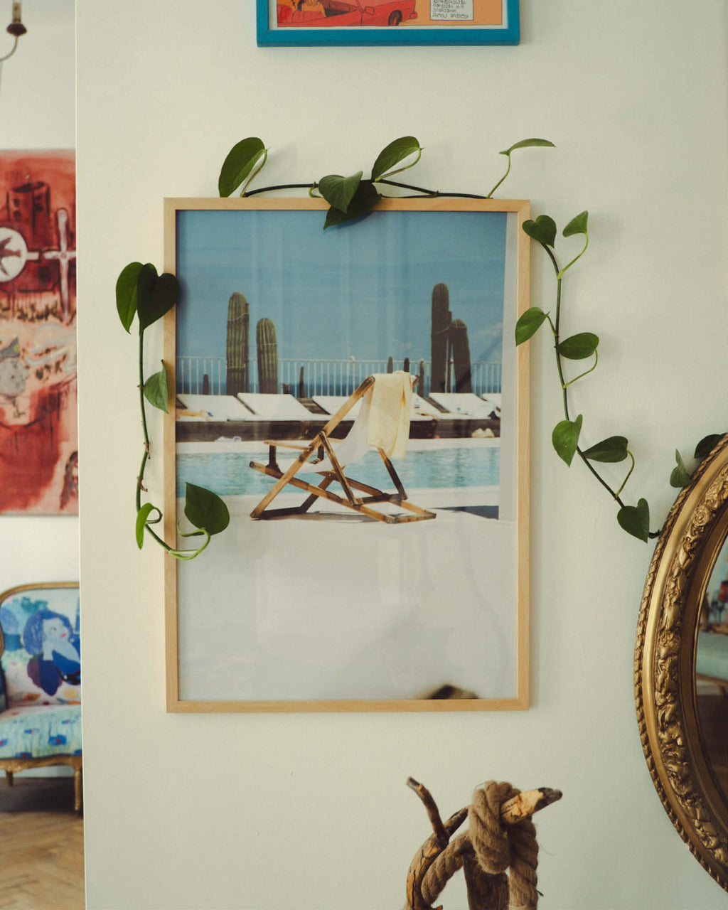 Framed picture of a pool scene on a wall with decorative elements