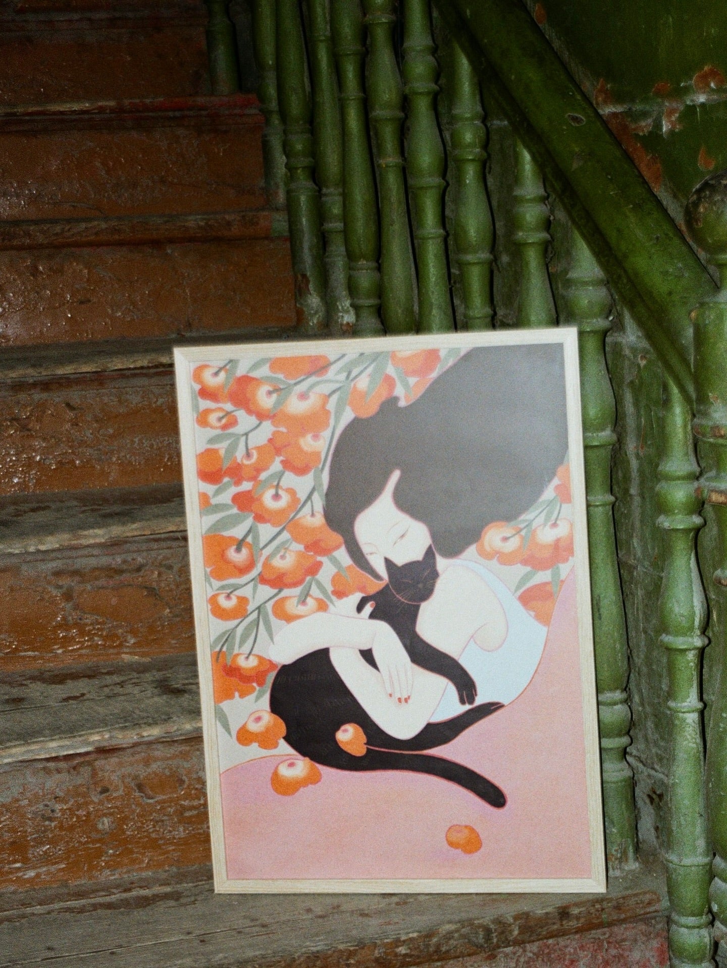 Poster of a woman with a cat surrounded by flowers, poster standing on stairs, green background