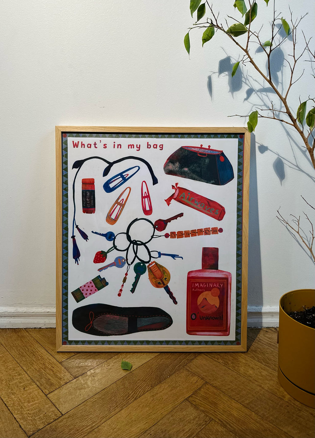 A framed poster with the title 'What's in my bag' featuring illustrations of various personal items like keys and skincare products, arranged on a white background.