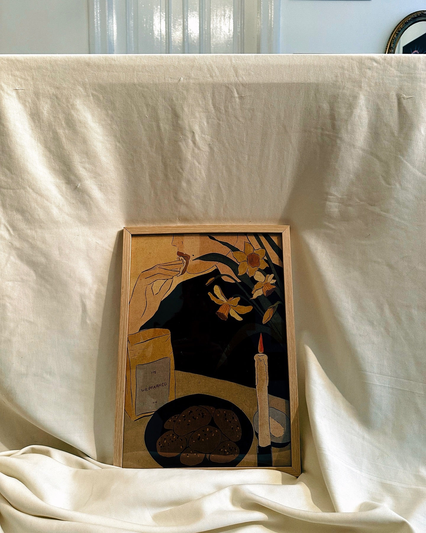 A poster displaying an illustration by Lea Woo featuring a nostalgic scene with a woman and nature elements, set against a plain background.