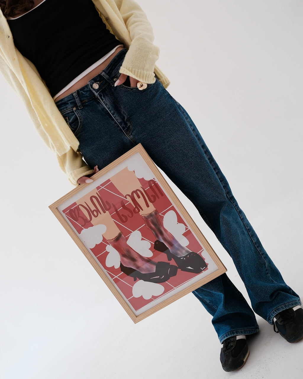 Person holding a framed artwork with design from georgian artist, with georgian words on a white background