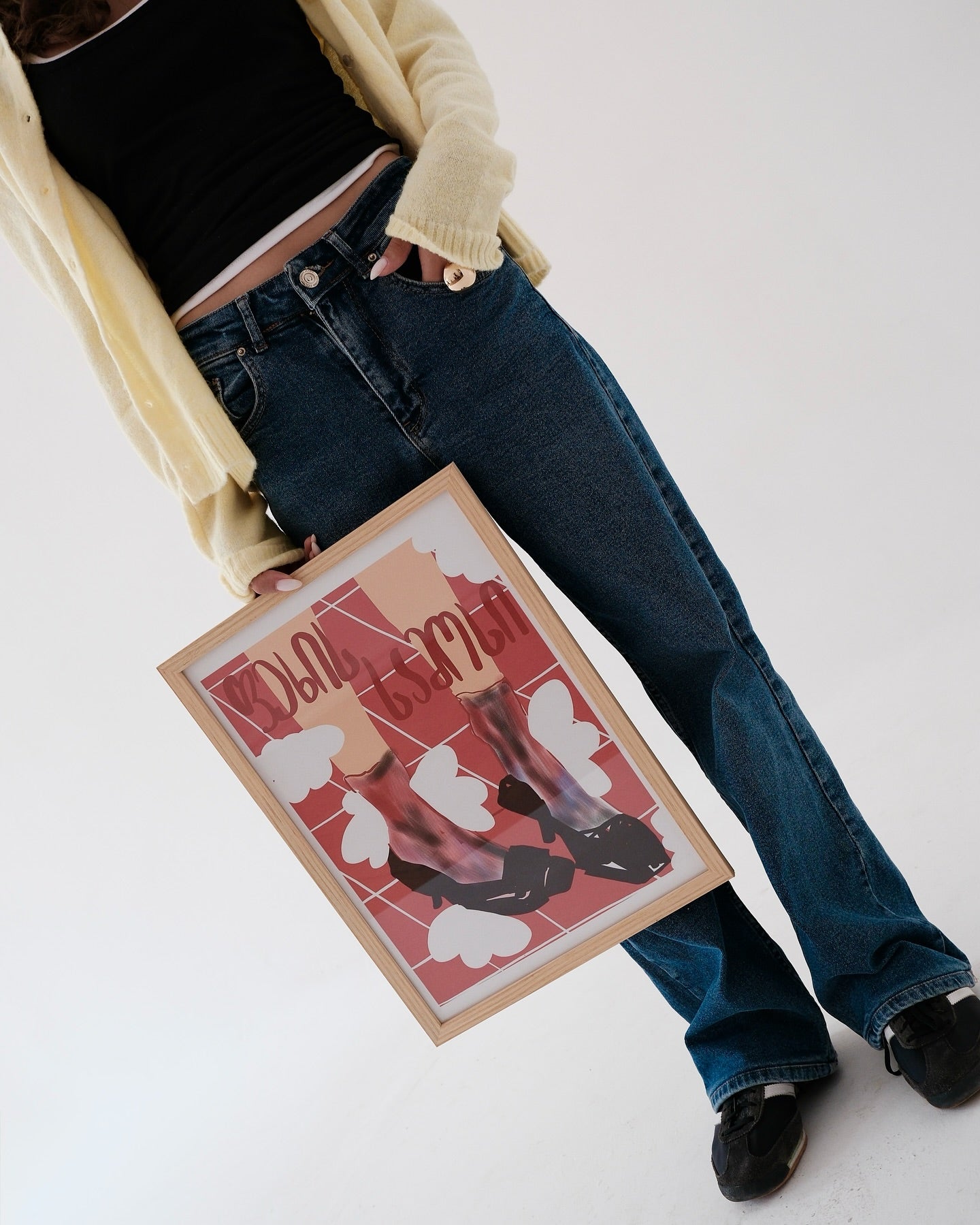 Person holding a framed artwork with design from georgian artist, with georgian words on a white background