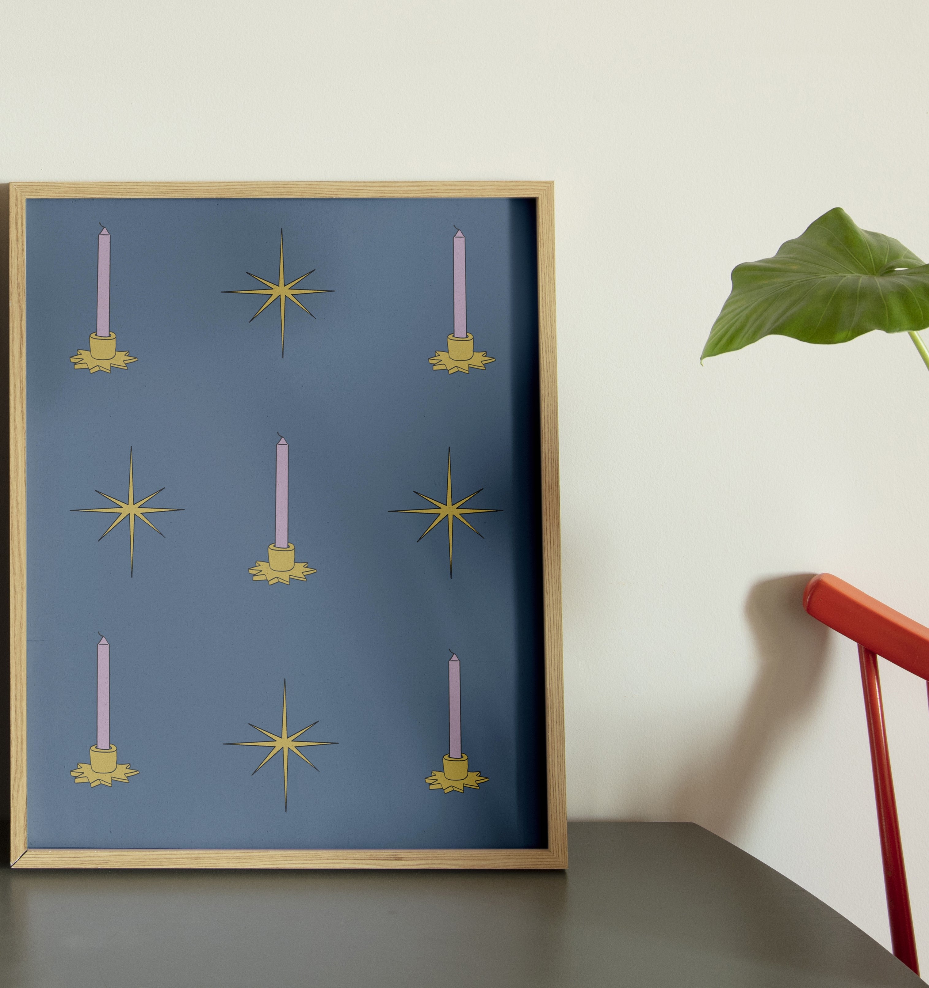 A framed poster with a blue background featuring illustrations of candles and stars, displayed against a wall with a plant to the side. Golden candle minimalist wall art poster in wooden frame by DAE