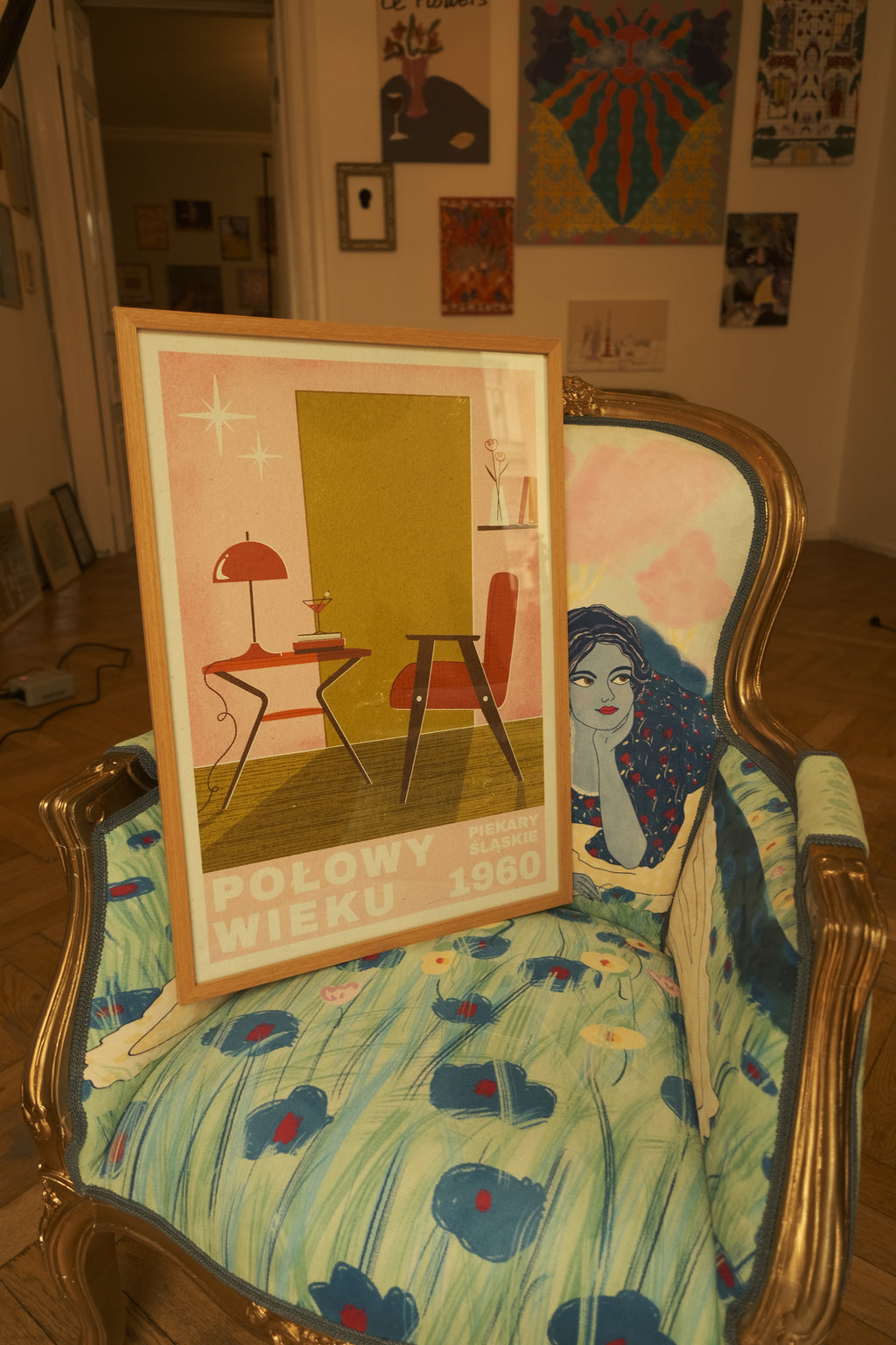 poster with mid century vibe in DAE's space, standing in chair with vintage vibe