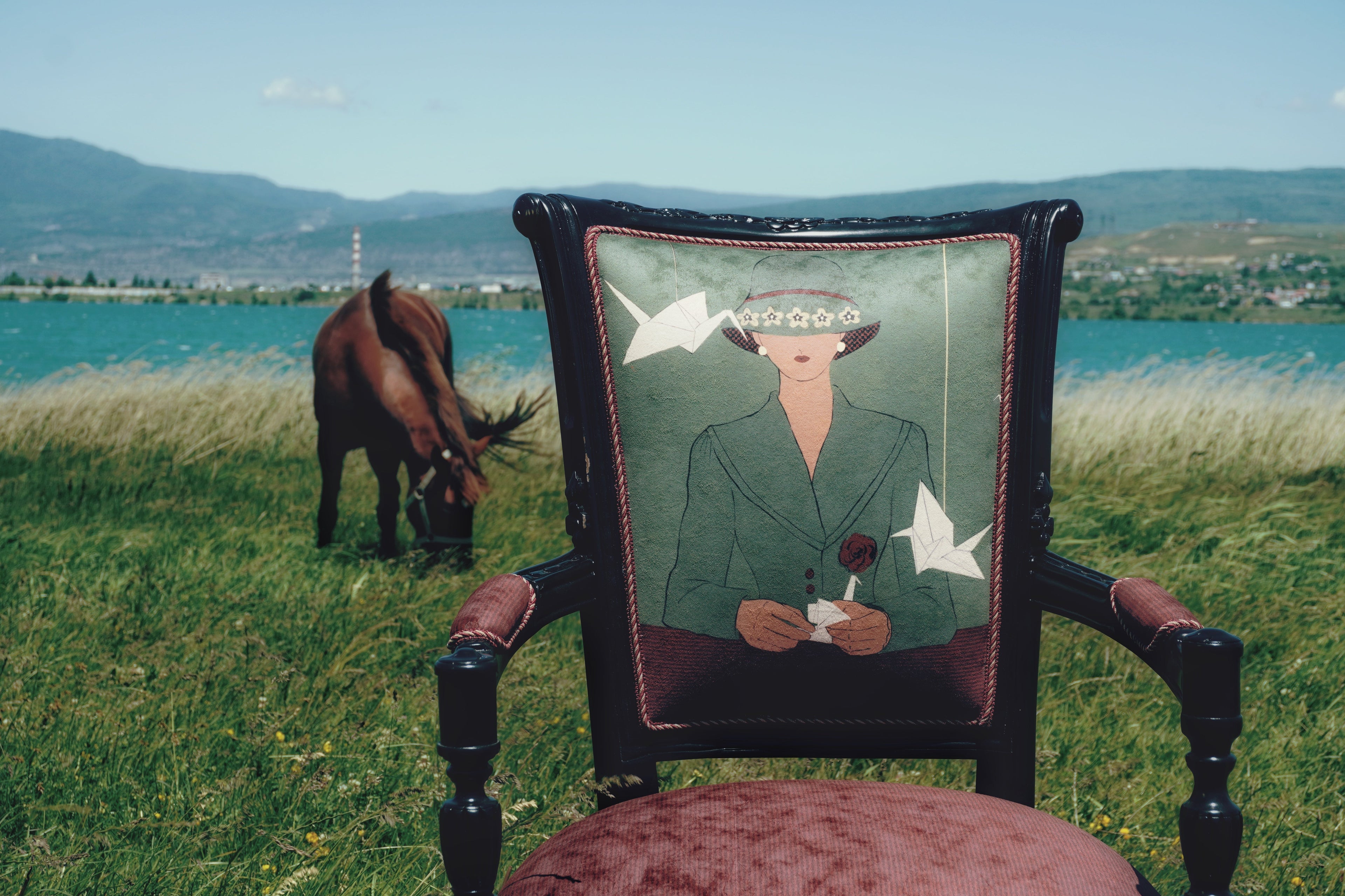 Vintage Chair with a painting of a woman, with paper cranes, japanese aesthetic, restored by DAE, on the background in the photo there is lake and horse