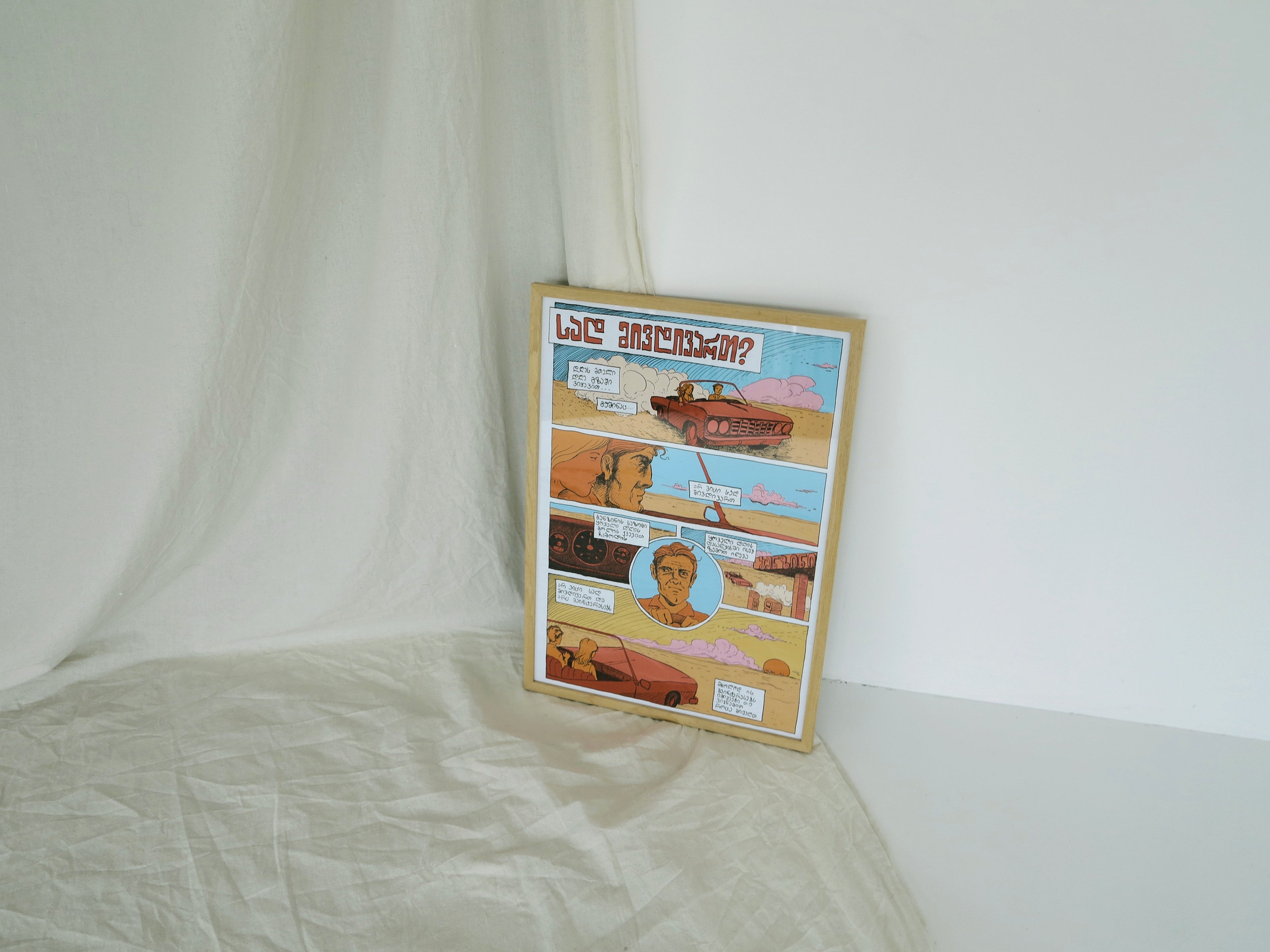 A poster with various images and text, presented in a frame, with a white backdrop.