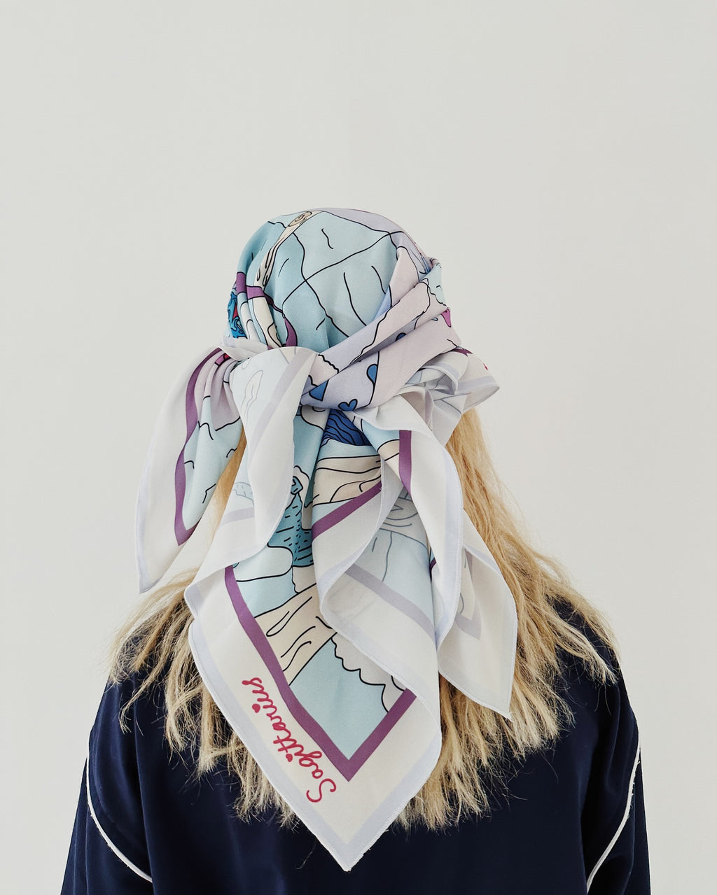 Sagittarius zodiac illustrated silk scarf hanging to show detailed symbolic artwork in light, airy tones