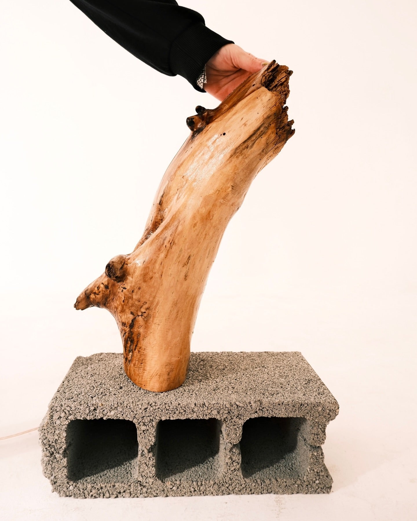 Handmade Wooden Lamp by DAE placed on a concrete block with a white background