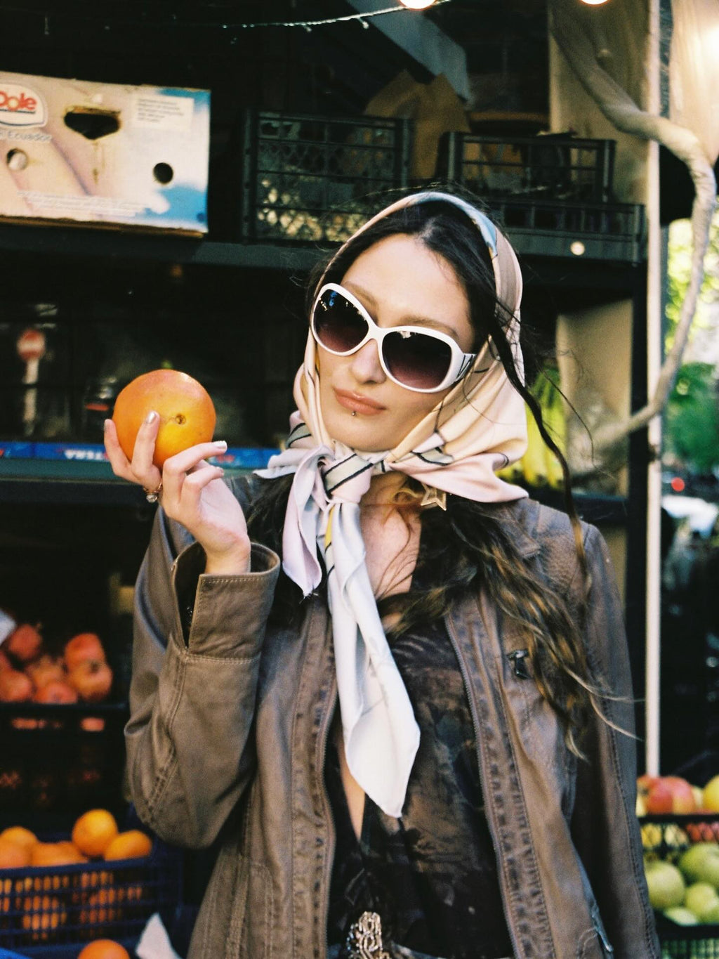 scarf by lea woo and dae, girl wearing in  tbilisi, holding orange in hand